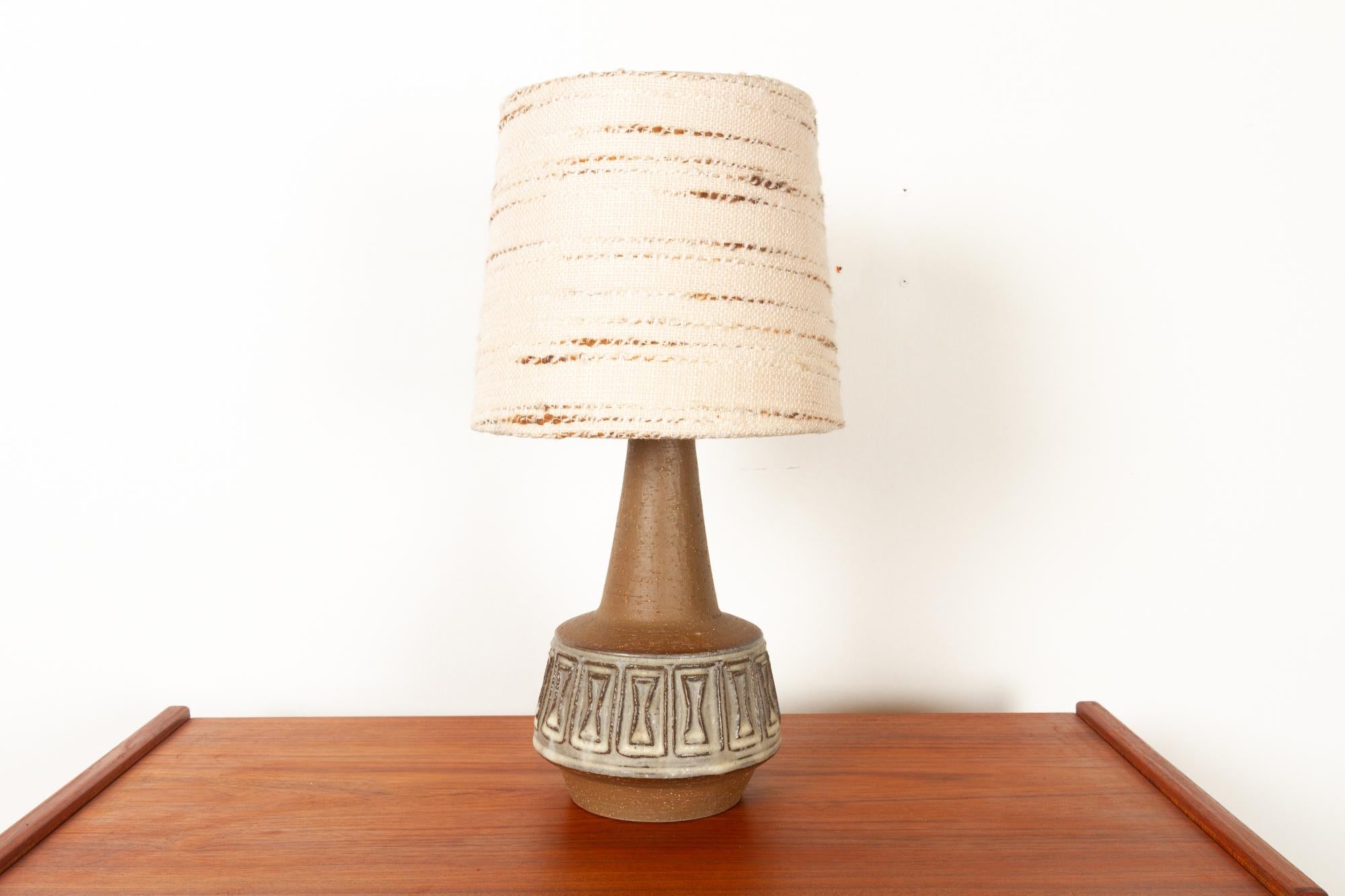 Danish stoneware table lamp by Helge Bjufstrøm for Michael Andersen 1960s
Danish Mid-Century Modern ceramic lamp in brown stoneware with original shade. Geometric tribal pattern in cream colored glaze. 
Made on the Danish island of Bornholm by the