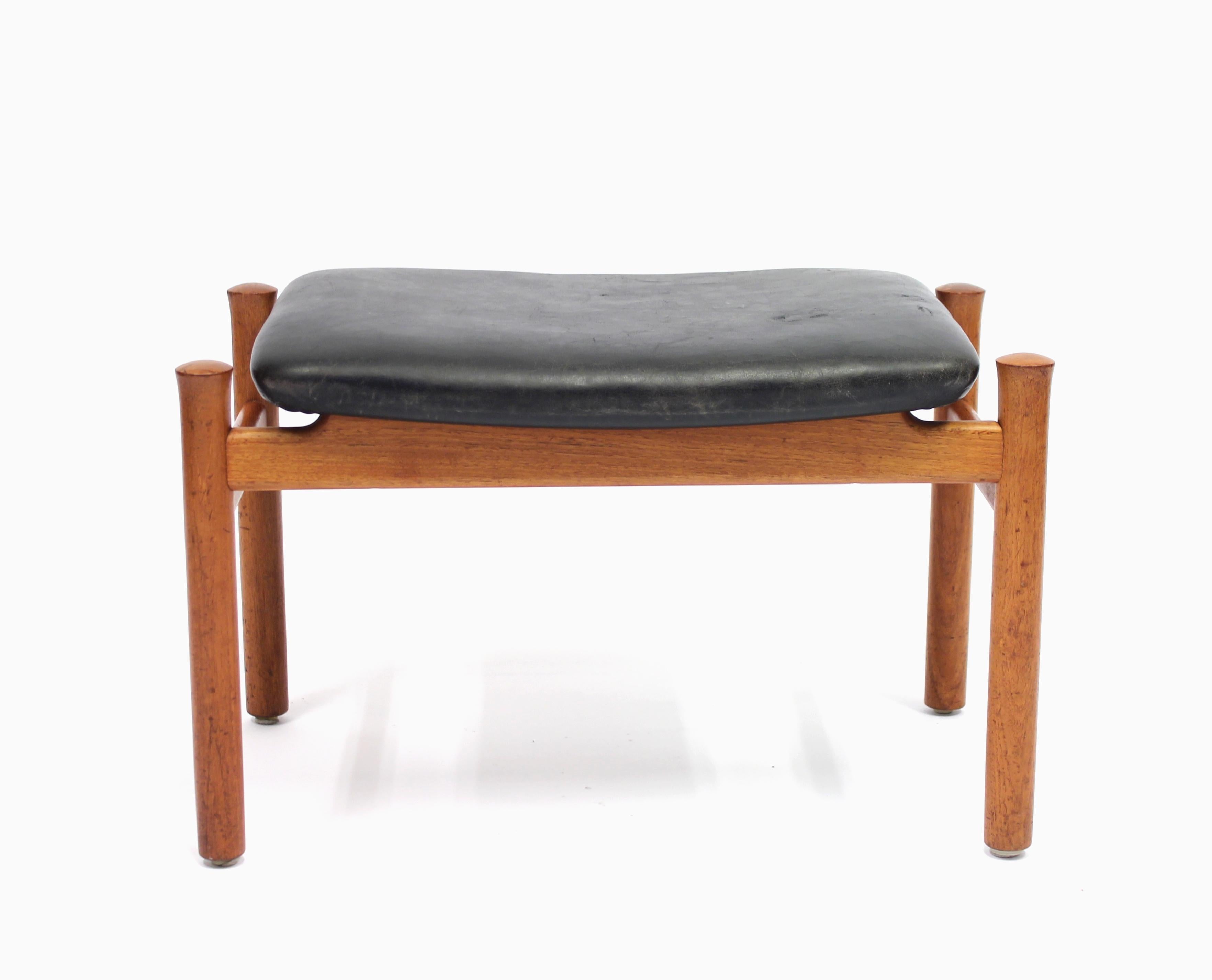 Stool / ottoman in teak and black leather designed by Søren Hansen for legendary Danish manufacturer Fritz Hansen in the 1960s. This example made in 1964. Untouched vintage condition with some ware consistent with age and use.