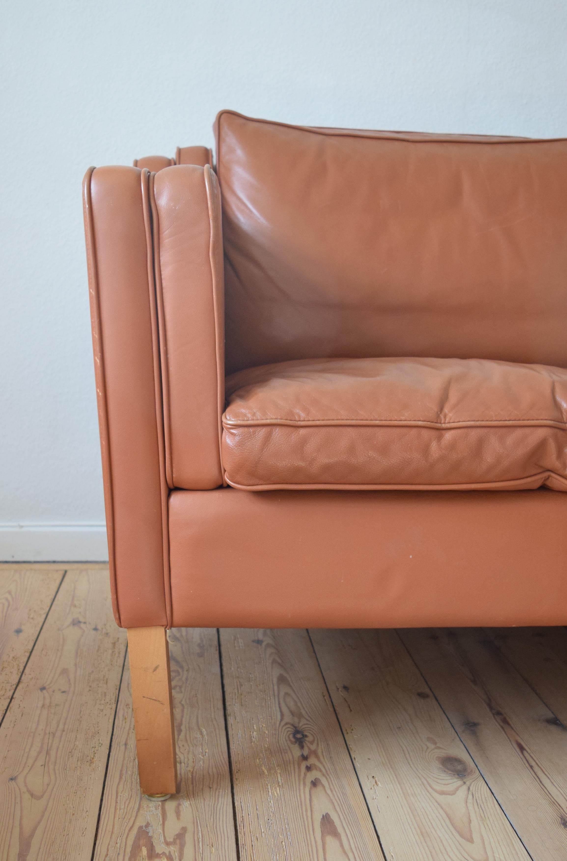 Scandinavian Modern 2 1/2-person cognac leather sofa. This sofa is covered in beautifully grained leather and sits on square beech legs. This sofa sat for many years in a Danish summer-house and shows very little wear for its age. Based on the 2213