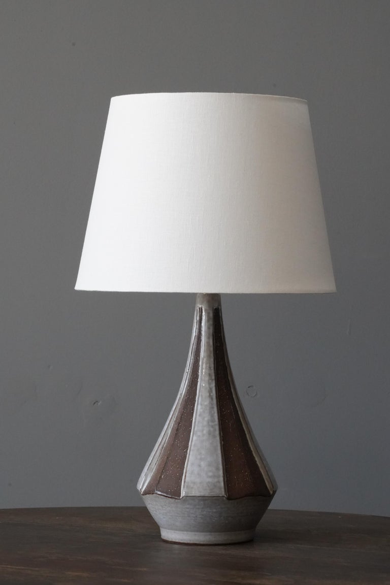 A sizable table lamp. In semi-glazed stoneware. Signed to bottom.

Stated dimensions exclude lampshade. Height includes socket. Sold without lampshade.

Glaze features brown-grey colors.