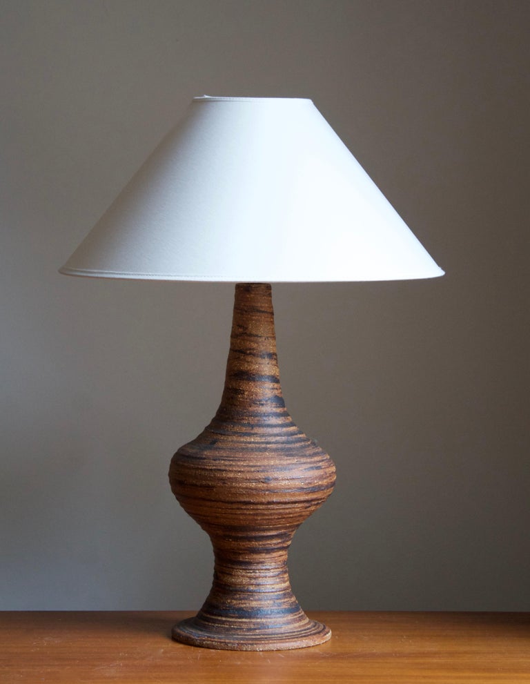 A sizable table lamp. In glazed stoneware. Signed to bottom.

Stated dimensions exclude lampshade. Height includes socket. Sold without lampshade.

Glaze features a brown color.