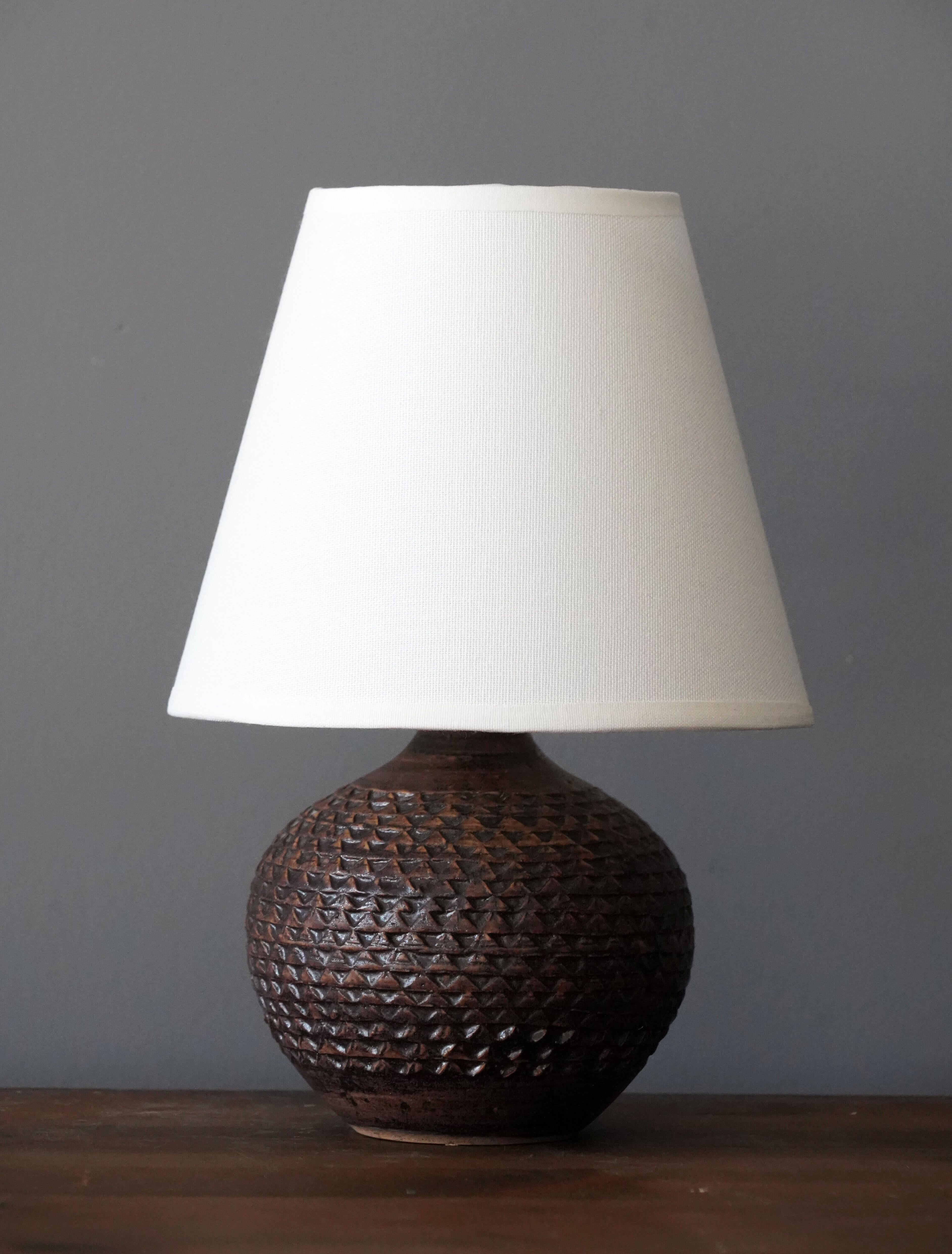 A small table lamp produced and design by unknown Danish studio potter.

Lampshade is attached for reference and are not included in the purchase. Measured without lampshade.

Other ceramicists of the period include Axel Salto, Arne Bang,