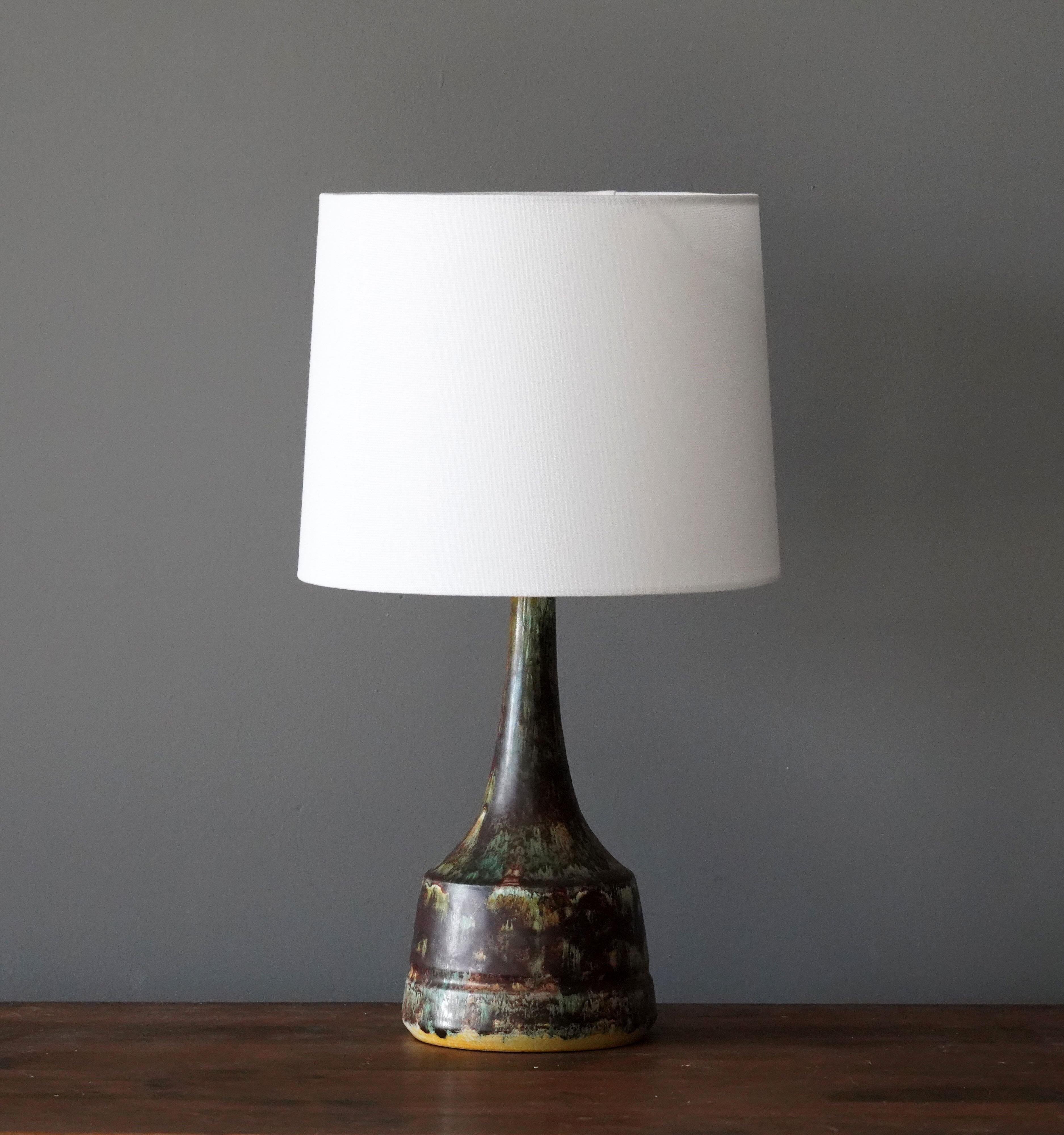 A table lamp produced and design by unknown Danish studio potter.

Lampshade is attached for reference and are not included in the purchase. Measured without lampshade.

Glaze features brown-green-yellow colors.

Other ceramicists of the period