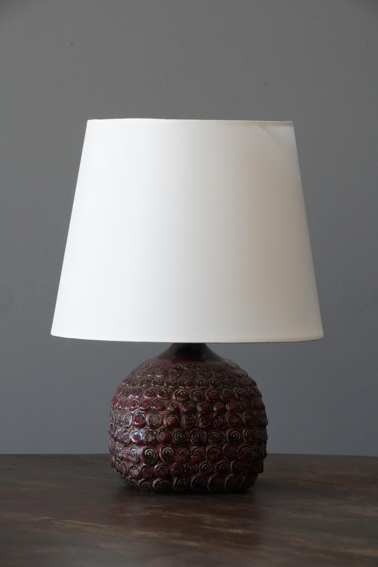A table lamp. In glazed stoneware in budded style. Signed to bottom.

Stated dimensions exclude lampshade. Height includes socket. Sold without lampshade.

Glaze features brown-red colors.