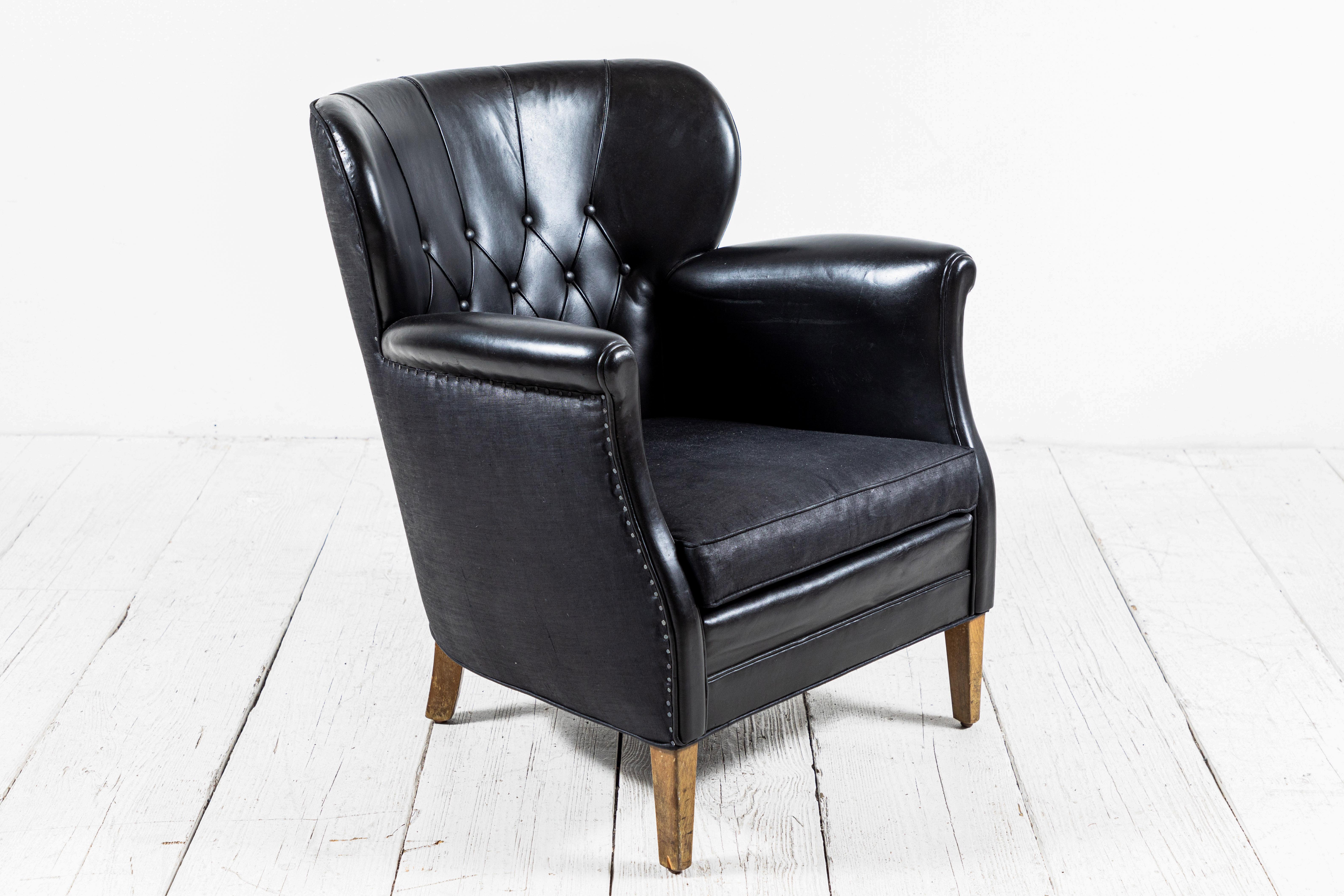 Danish style black leather tufted pair of chairs with slight winged sides. Black beetled linen and been added to the back of the chairs and seat cushions.
