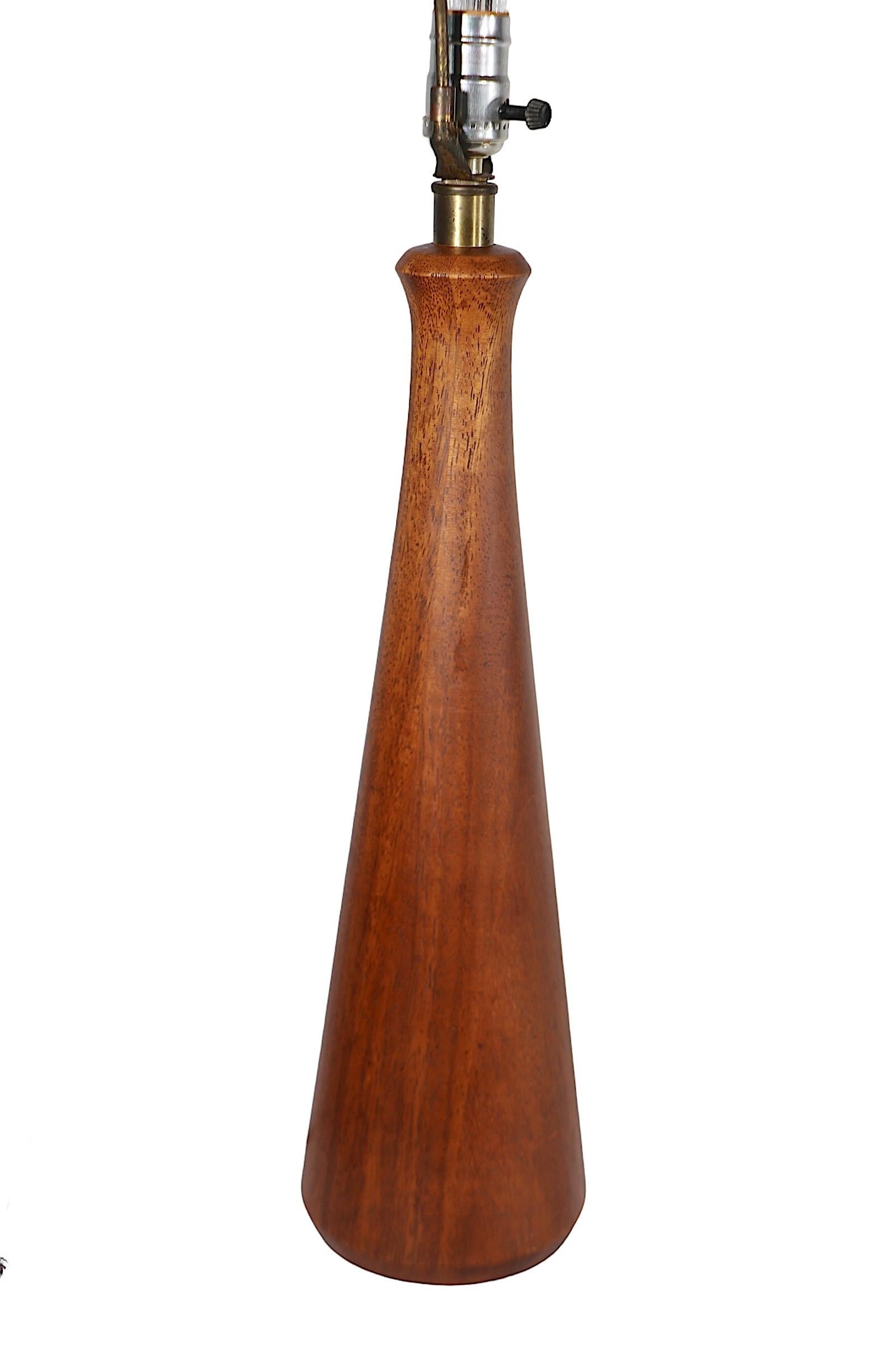 Sophisticated architectural wood table lamp, having a solid wood ( probably walnut )  body, which has a narrow neck at the top and widens toward the base. We believe the lamp was made in the USA, in the Danish style, it is circa 1950/60's, in very