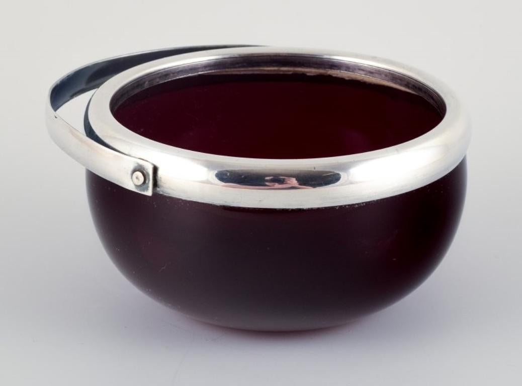 Dänische Zuckerdose aus weinrotem Glas mit silberner Fassung und Henkel.
1920/30s.
In ausgezeichnetem Zustand.
Abmessungen: Höhe ohne Griff 5,5 x Durchmesser 11,0 cm.
