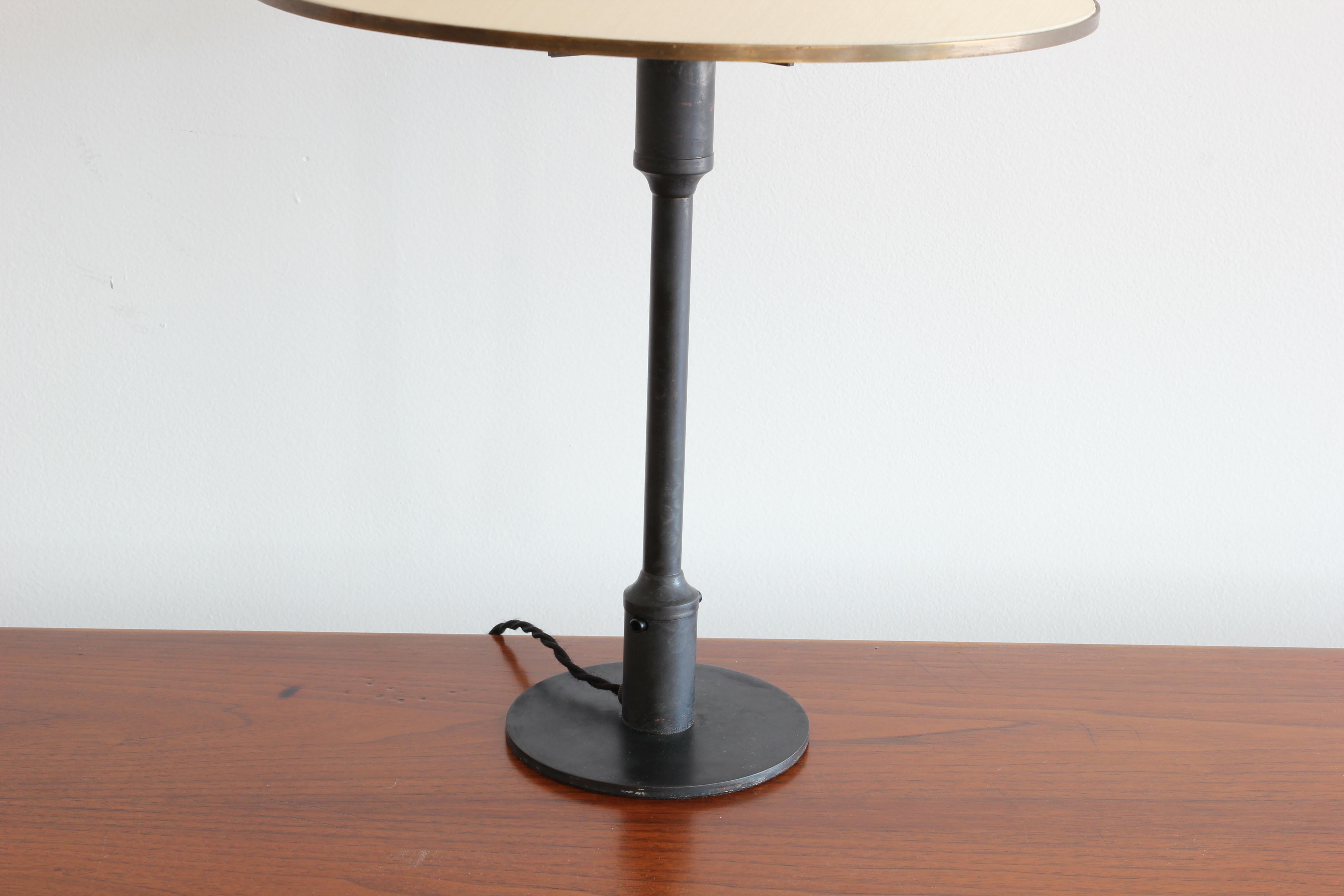 Incredible burnished bronze table lamp with cone shade called the Kongelys Lamp by Niels Rasmussen Thykier for Fog & Mørup. Original metal fittings on shade. 

A pair is also available.

 