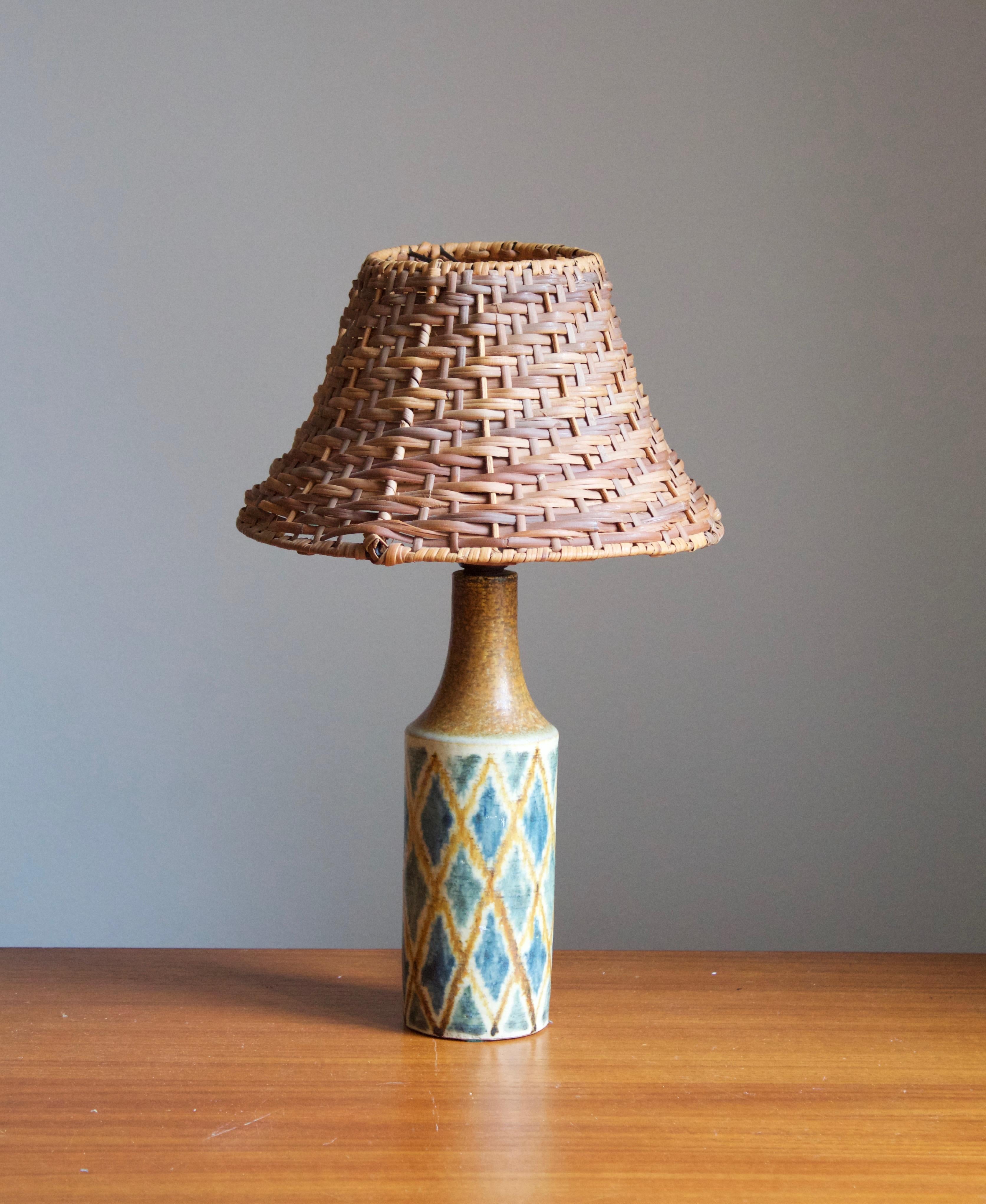 A small table lamp, designed and produced in Denmark, c. 1950s. Stamped.

Stated dimensions exclude lampshade, height includes socket. Illustrated rattan lampshade can be included upon request.