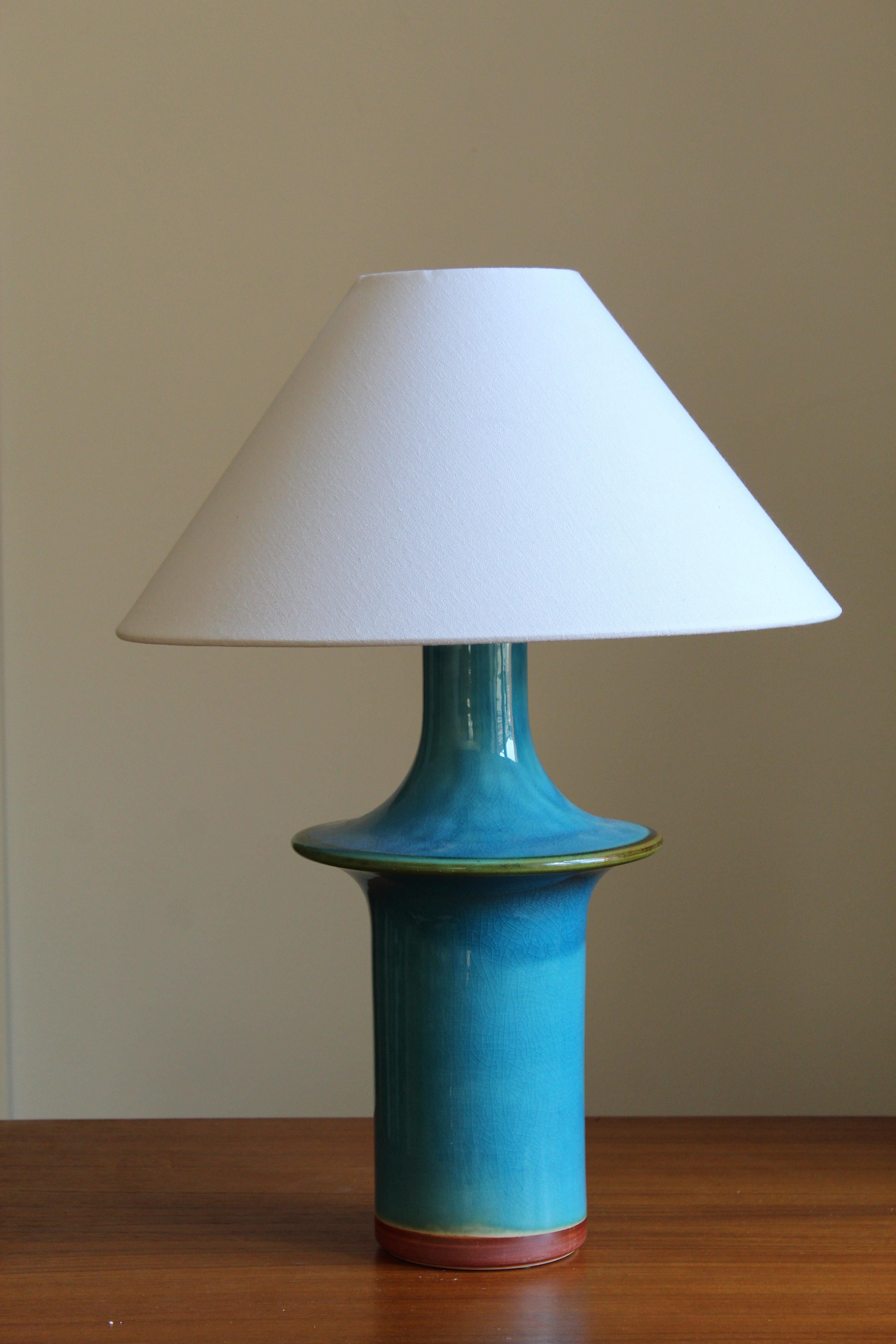 A Danish table lamp. Designed and produced in Denmark, 1960s. Sold without lampshade.

Glaze features a blue color.

 