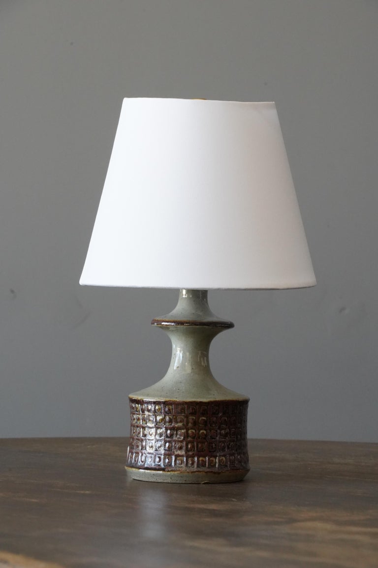 A table lamp. In glazed stoneware. Stamped to bottom.

Stated dimensions exclude lampshade. Height includes socket. Sold without lampshade.

Glaze features brown-green colors.