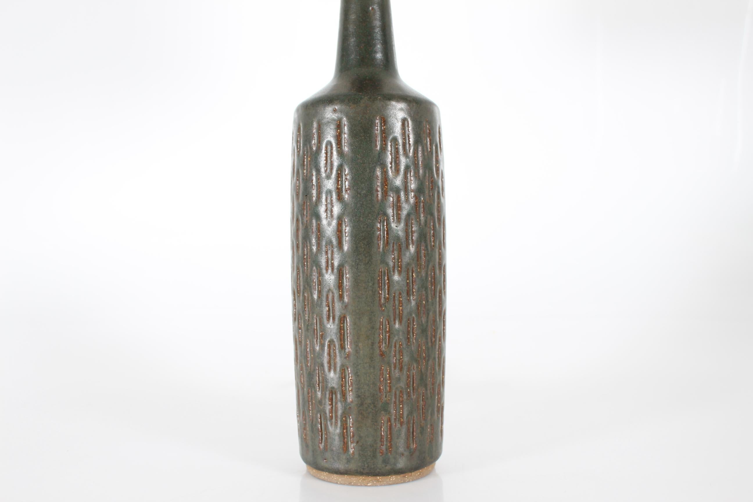 Lampada da tavolo in ceramica danese di metà secolo Greene & Greene, alta e slanciata, con smalto verde scuro su un motivo inciso.
La lampada è stata disegnata da Per Linnemann-Schmidt e prodotta nello studio e nel laboratorio di sua moglie nel