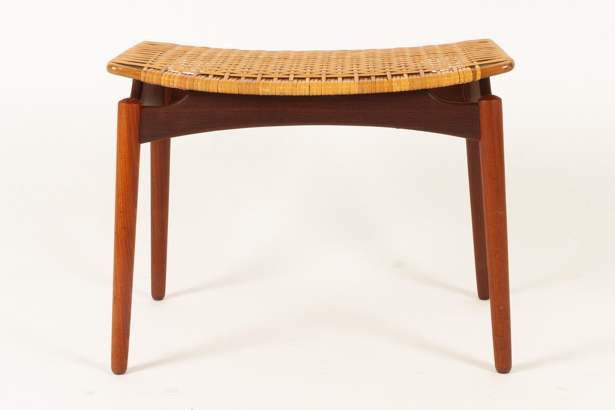 Danish teak and cane stool from Ølholm Møbelfabrik, 1950s
Stylish and elegant Mid-Century Modern footstool in solid teak with cane seat. Round tapered legs and curved seat. The recessed corners gives the seat a floating appearance. A very beautiful