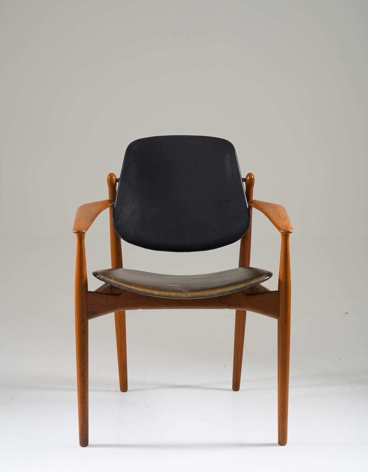 Black leather and teak chair by Arne Vodder for France & Daverkosen, Denmark.
The chair has a wonderfully neat design and has perfect proportions. And the most beautiful part of the chair is the sculptural piece of wood holding the backrest. 
The