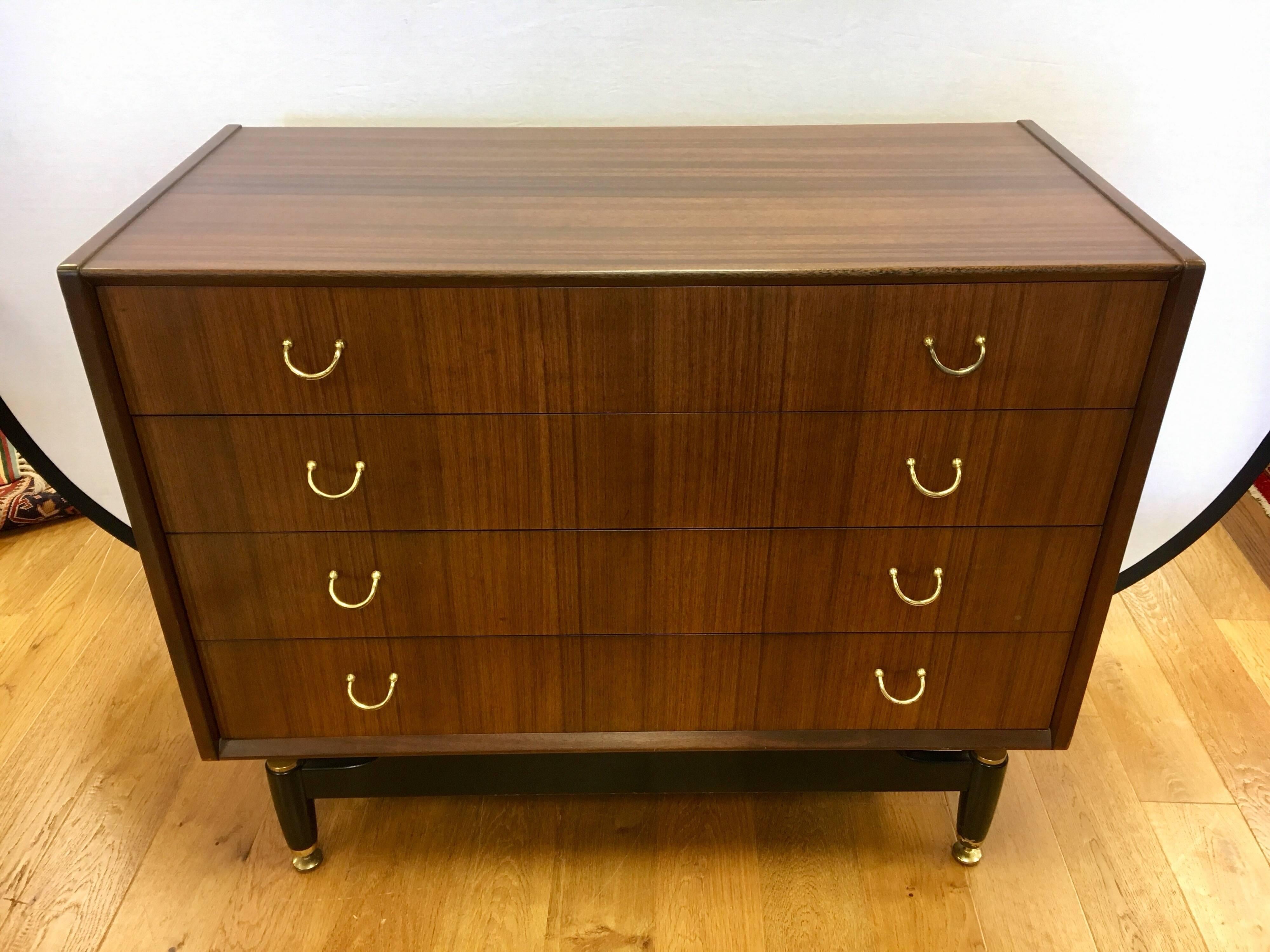 Kofod Larsen designed this floating dresser for Gomme's G-Plan Danish Range in the 1960s. It is a masterful piece composed of a two-tone teak frame on a darker lacquered base with brass feet. There are four drawers with original brass pulls. 