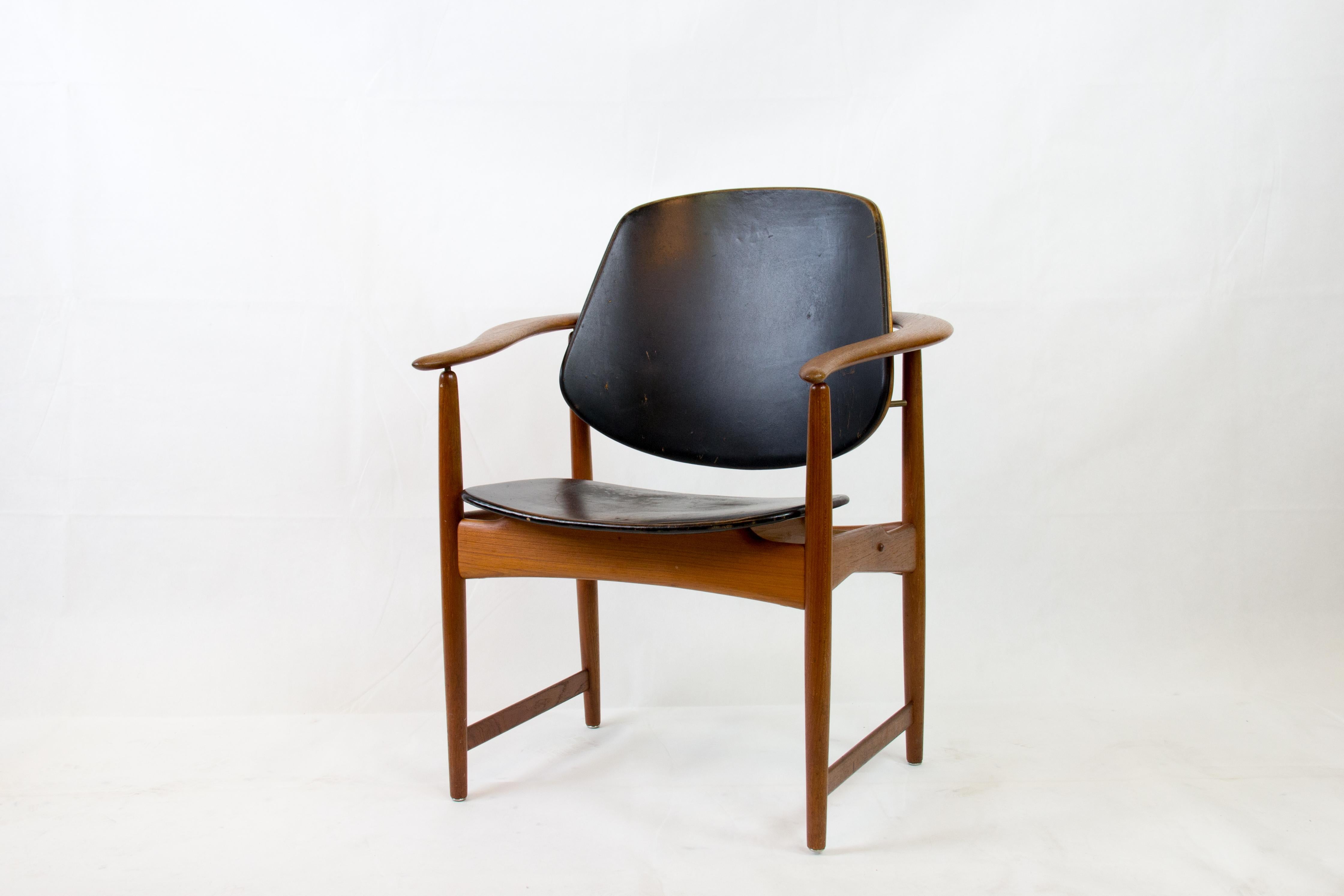 The Armchair Captain's Chair by Arne Hovmand Olsen, crafted in teak and leather in 1958, is a timeless piece of mid-century modern design. This iconic chair features a sleek teak frame with elegant curves and a comfortable leather seat and backrest.