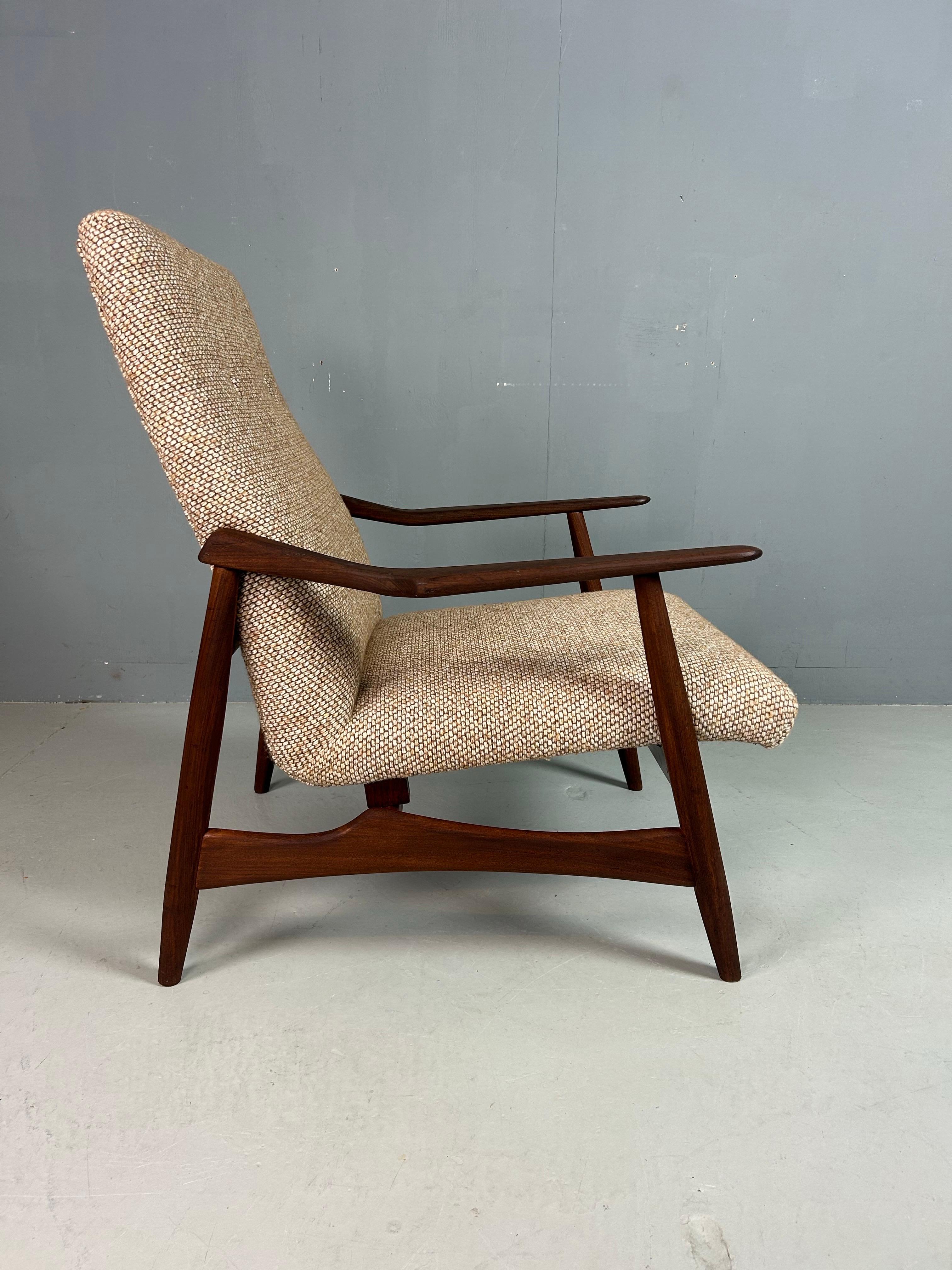 Una poltrona classica Danish Teak Classics degli anni '60, realizzata in teak massiccio con linee eleganti e scultoree. La struttura presenta le venature calde e la resistenza tipiche dell'artigianato danese di metà secolo, mentre i braccioli sono