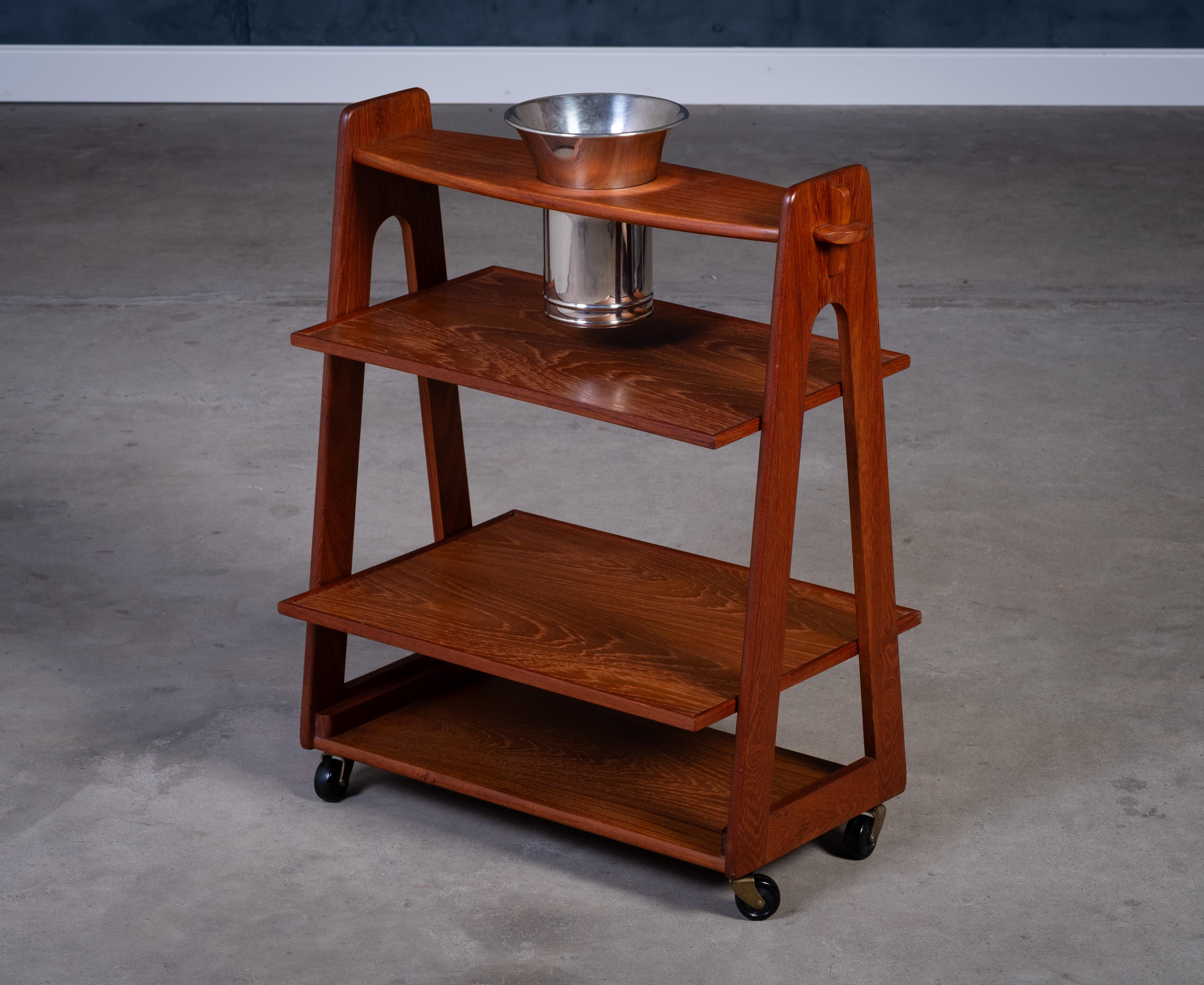 Elegant Danish bar table and serving trolley from the 1960s, crafted in warm teak wood and featuring a built-in champagne bucket. Stylish and practical, this compact serving trolley is perfect for entertaining and fits seamlessly into any modern