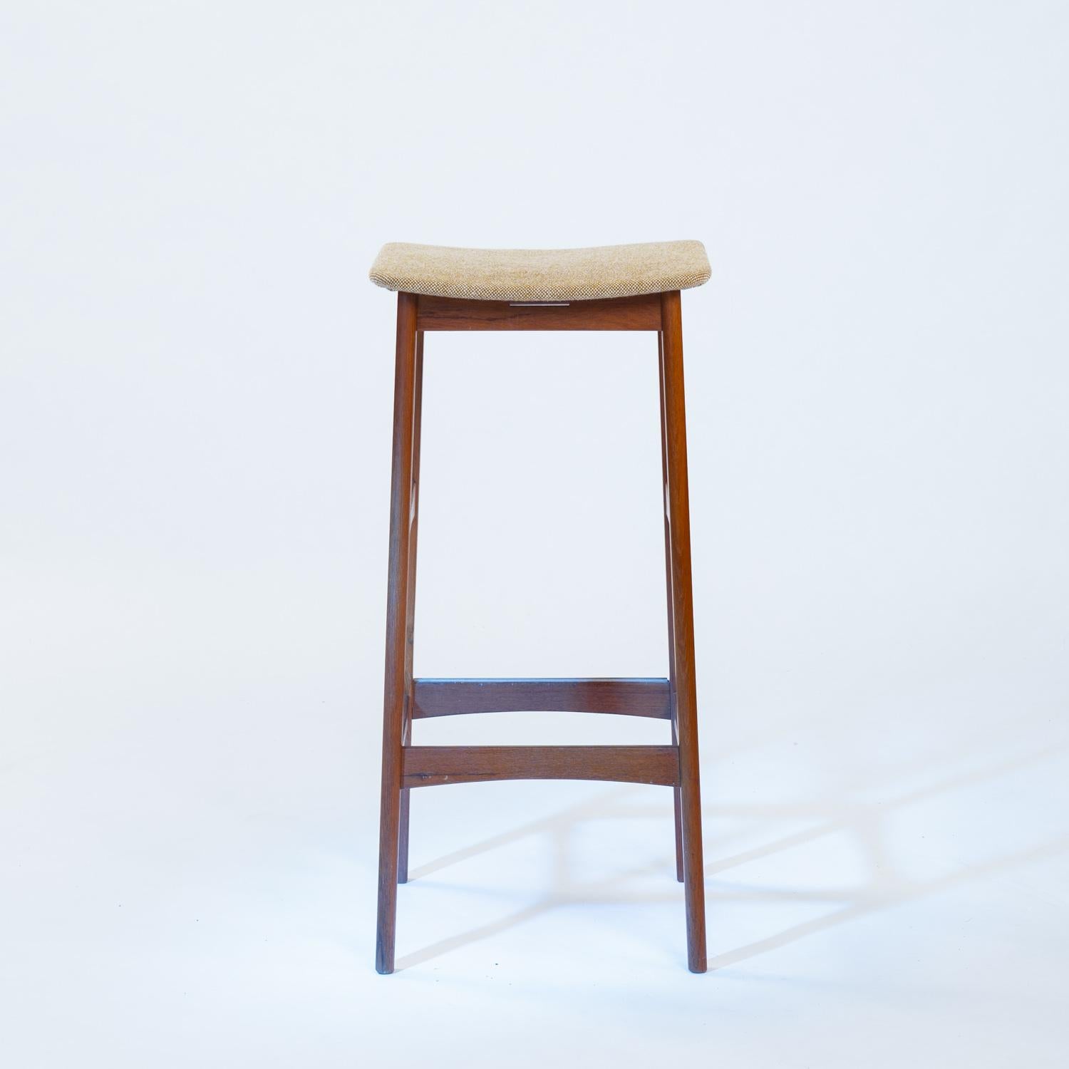 Satz von drei Barhockern aus Teakholz, entworfen von Erik Buch und hergestellt von Dyrlund. Diese klassischen Barhocker aus der Mitte des Jahrhunderts zeichnen sich durch ihre geschwungenen Teakholzrahmen und ihr ergonomisches Design aus und sind