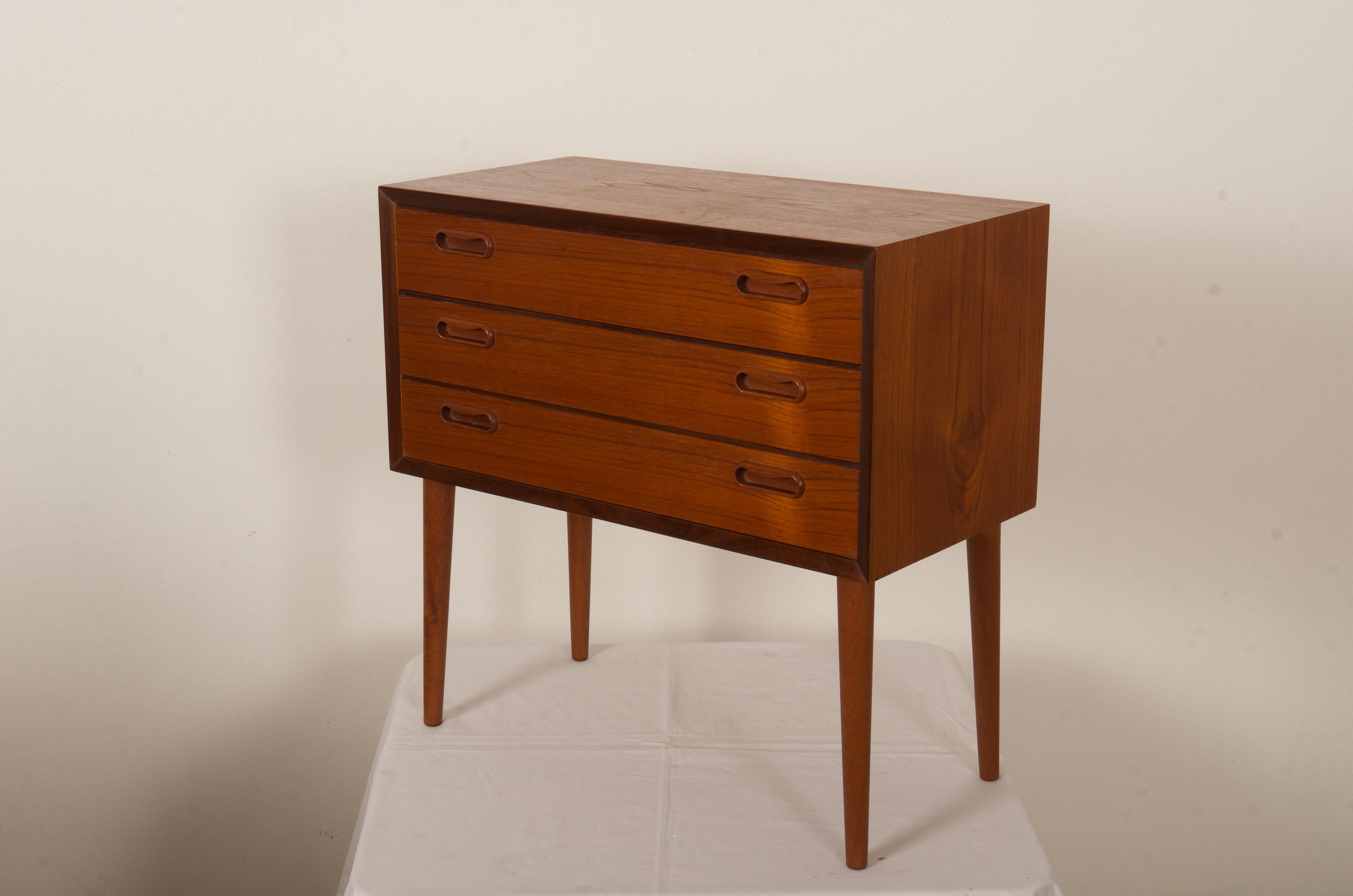 Teak bedside table, commode with three dovetailed drawers on slender, tapered, removable legs. Made in Denmark in the 1960's. Excellent used condition.