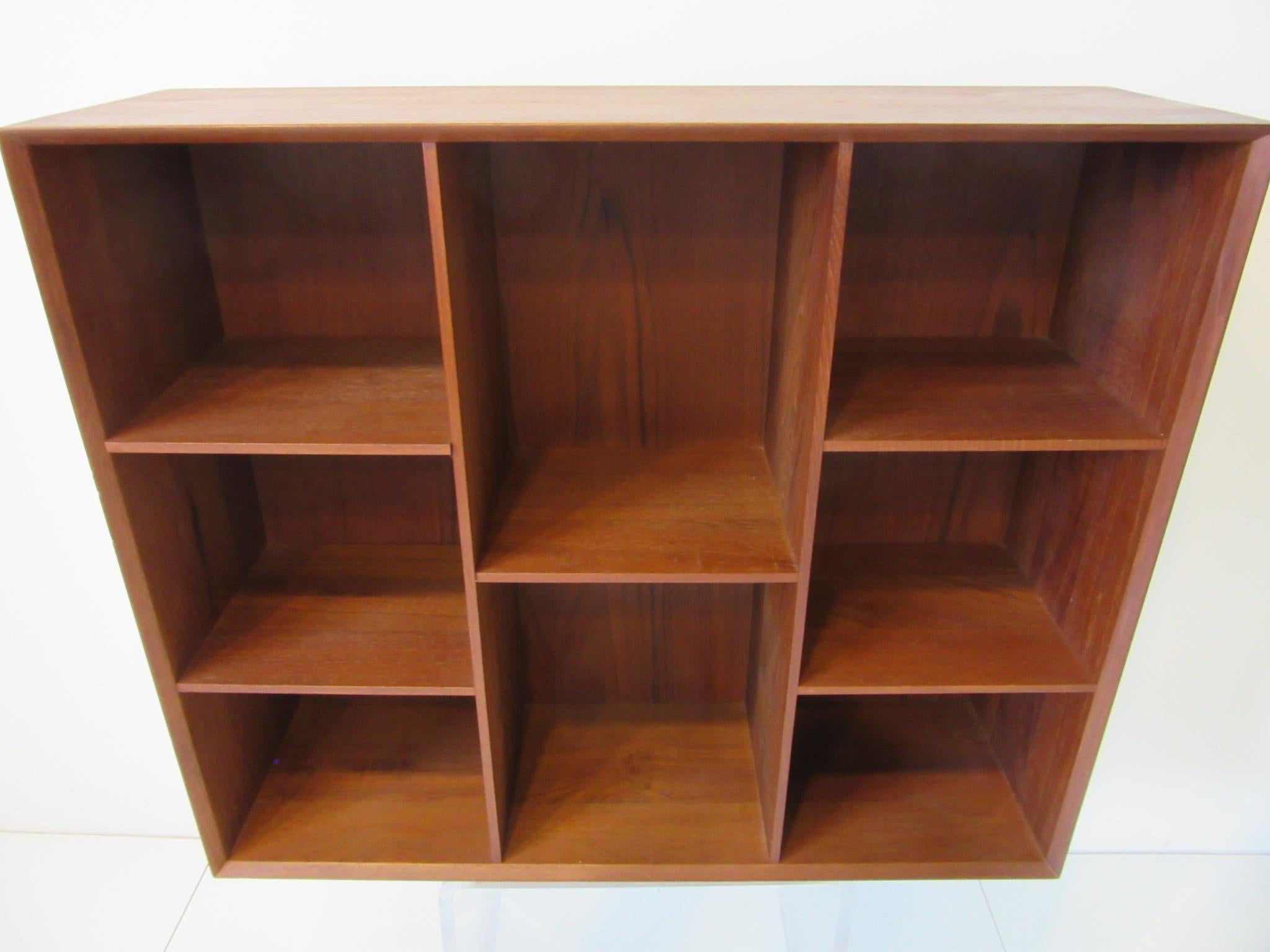 A well crafted teakwood bookcase with adjustable shelves to each side, a fixed shelve to the center and wonderful finger joinery to the corners and beveled front edges . Constructed at the height of handmade Danish Modernism's best period it can be