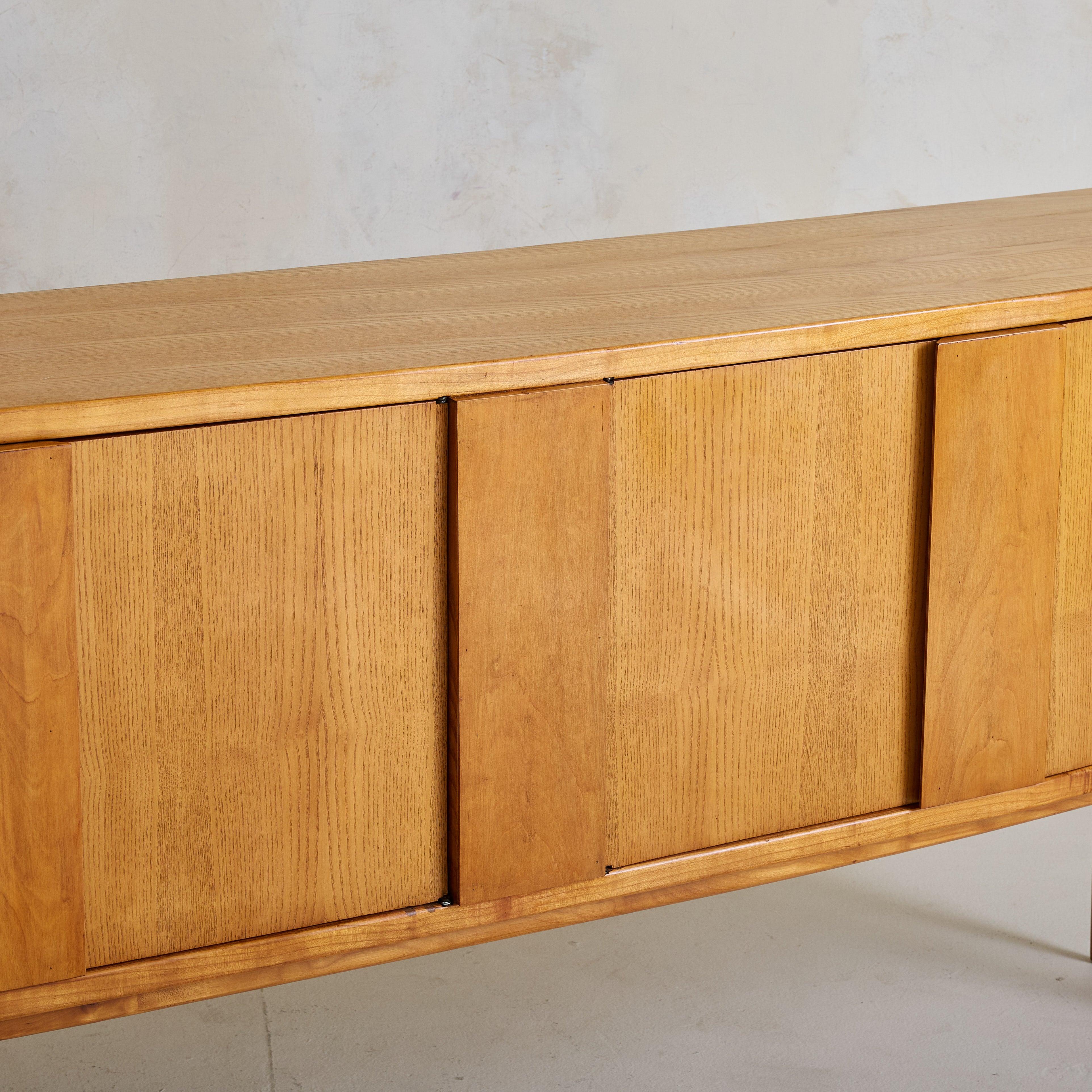 Una credenza danese moderna con arco degli anni '60 attribuita a Svend Madsen. Realizzato in teak dai toni caldi, il suo profilo elegantemente curvo ammorbidisce la tradizione rettilinea degli armadi di metà secolo. Le quattro ante a pannello piatto