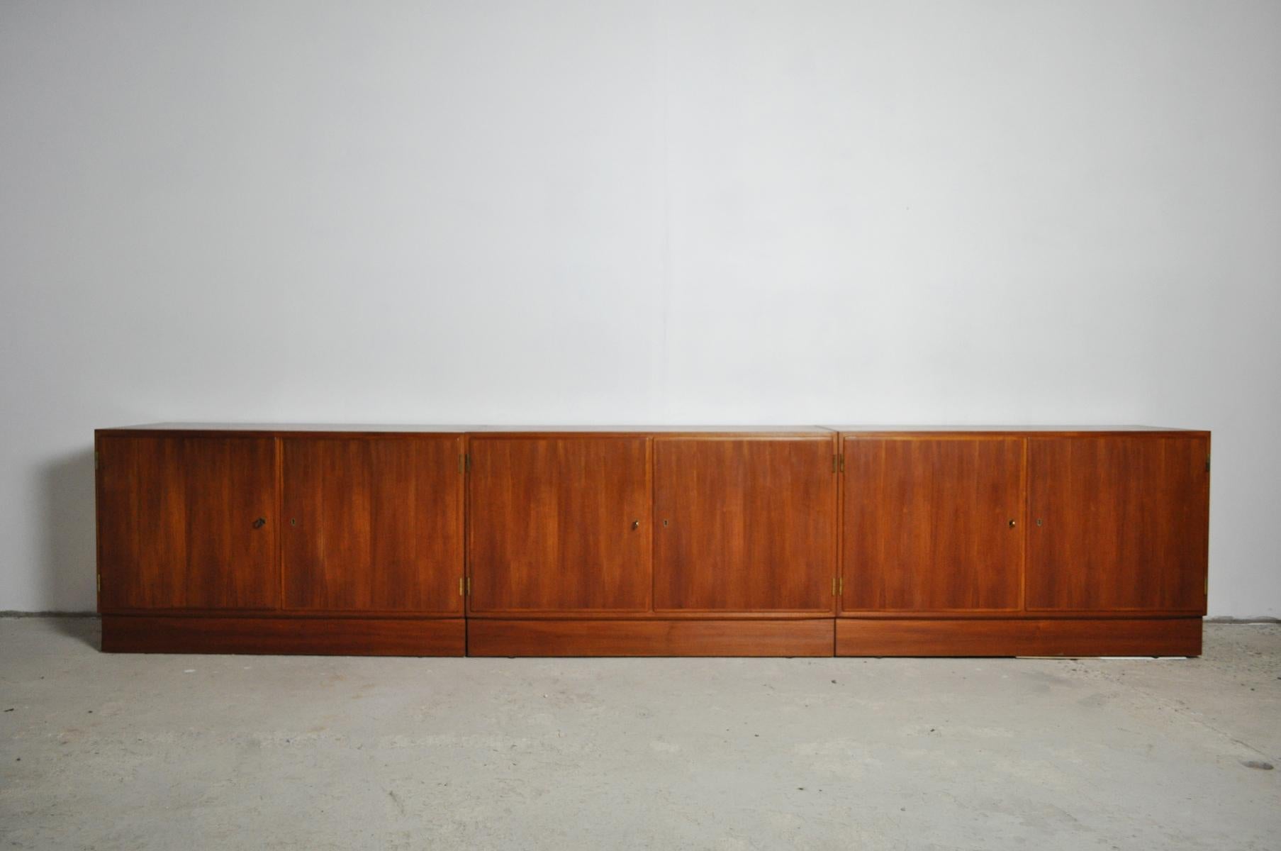 Three Danish teak cabinets/cupboards by Hundevad & Co. Made of veneered teak wood, fronts with each two doors. Set on sockets, these can be removed and legs can be fitted. Keys included.
Very fine craftsmanship as always from Hundevad.
Signs of