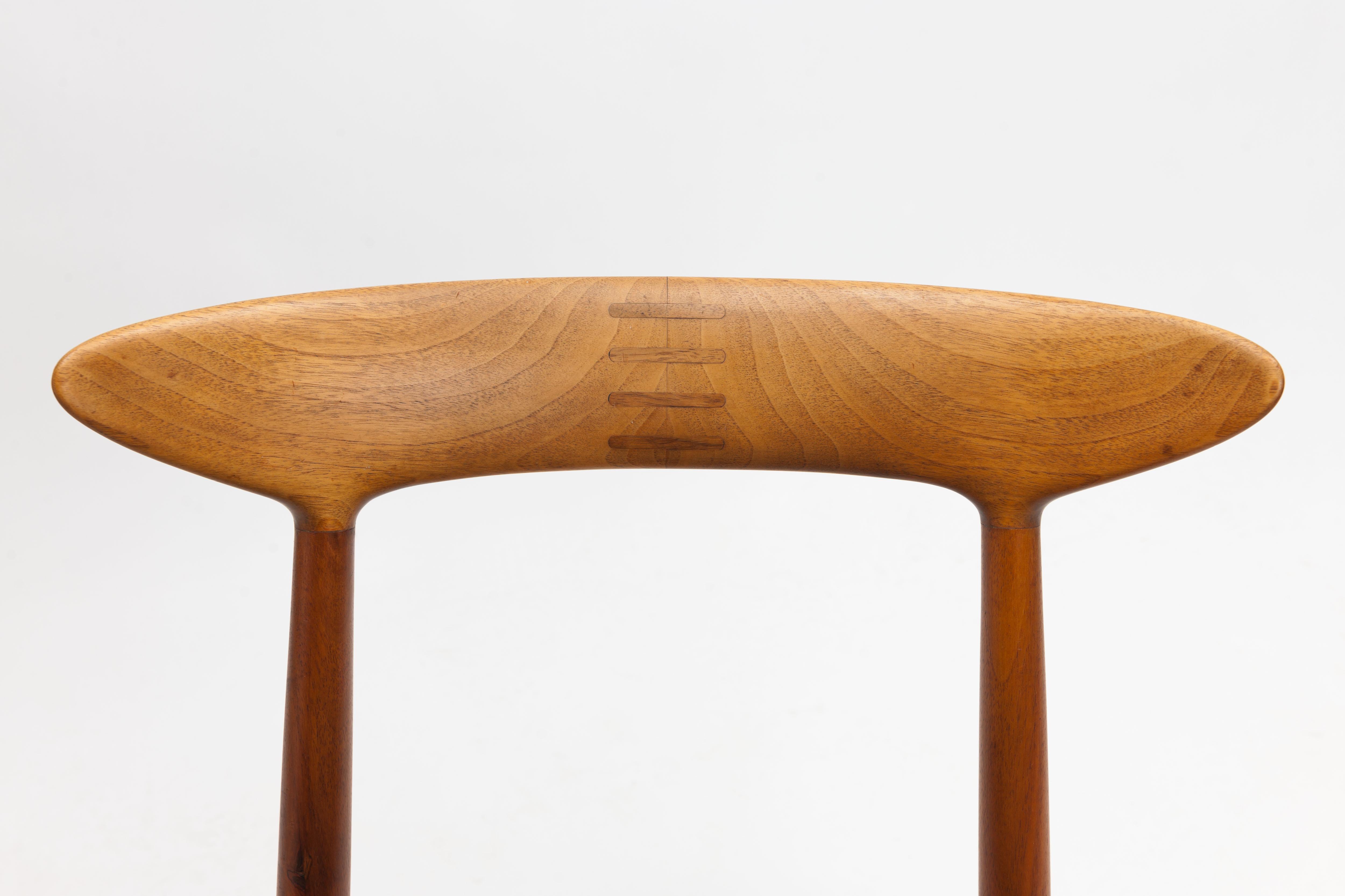 Beautiful single chair made of solid teak with exceptional wooden inlay detailing in the backrest. 
A 1950s design (1955) by Danish designer Kurt Østervig for Brande Møbelindustri Denmark.
The seat is executed in beautiful quality vintage vegetal