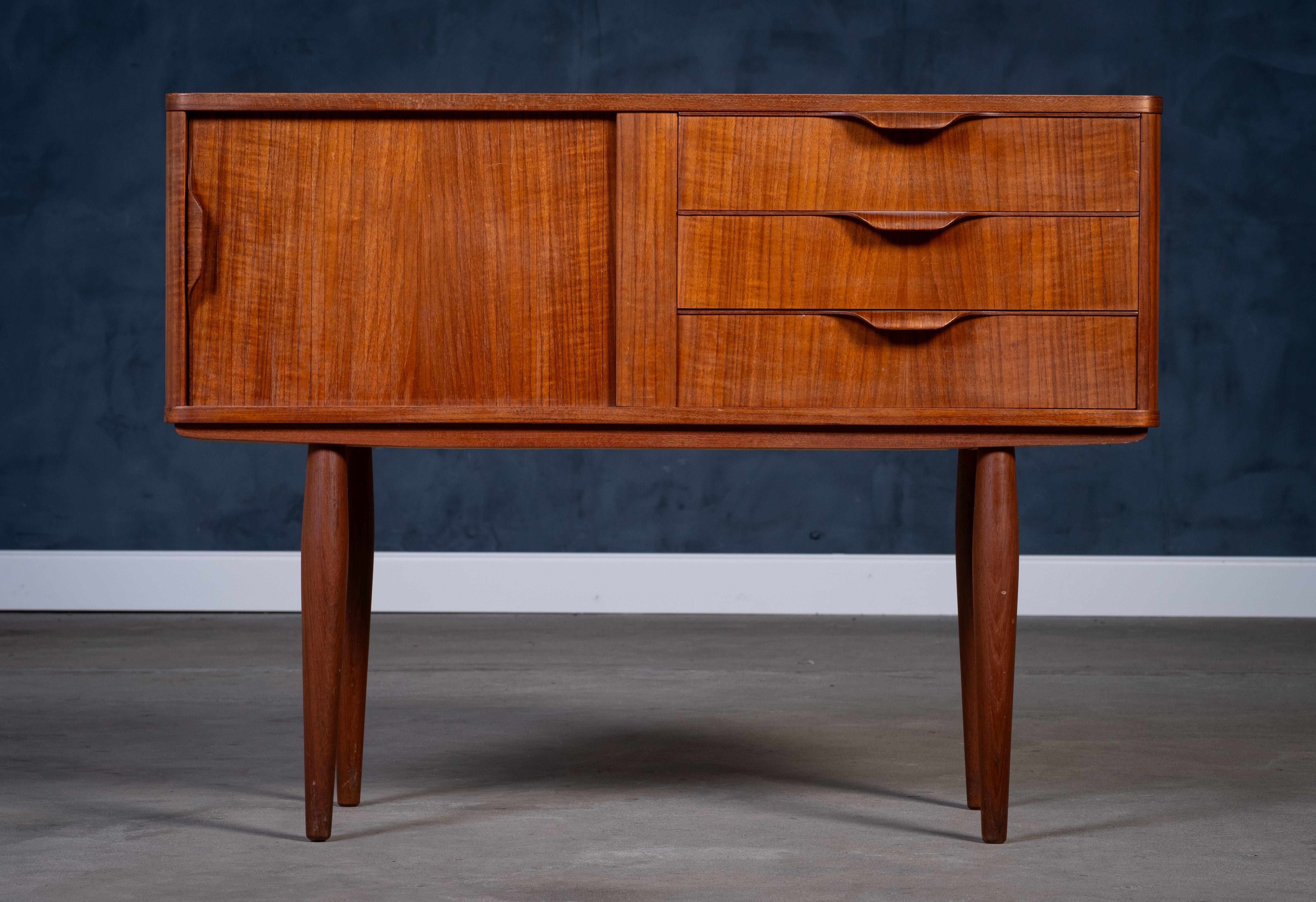 Elegante cassettiera danese di metà secolo attribuita ad Aksel Kjersgaard, realizzata in caldo legno di teak negli anni Sessanta. Questo pezzo versatile è dotato di tre cassetti e un'anta, per offrire un pratico spazio di archiviazione in una forma