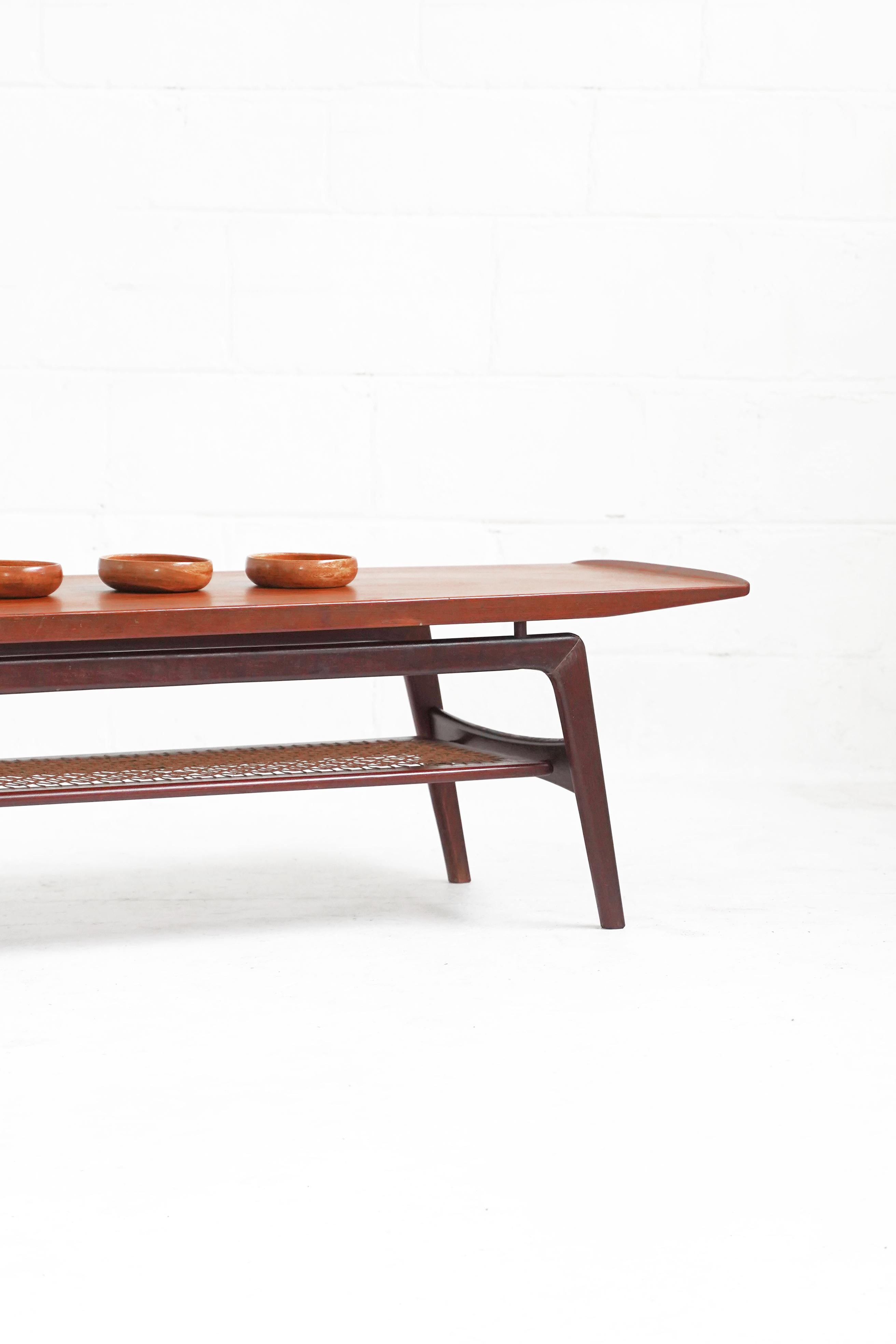 Stunning teak coffee table by Arne Hovmand-Olsen with lower corded shelf fully intact and evenly spaced. In overall good vintage condition with minor wear throughout. Repair done to leg, structurally sound - shown in photos.