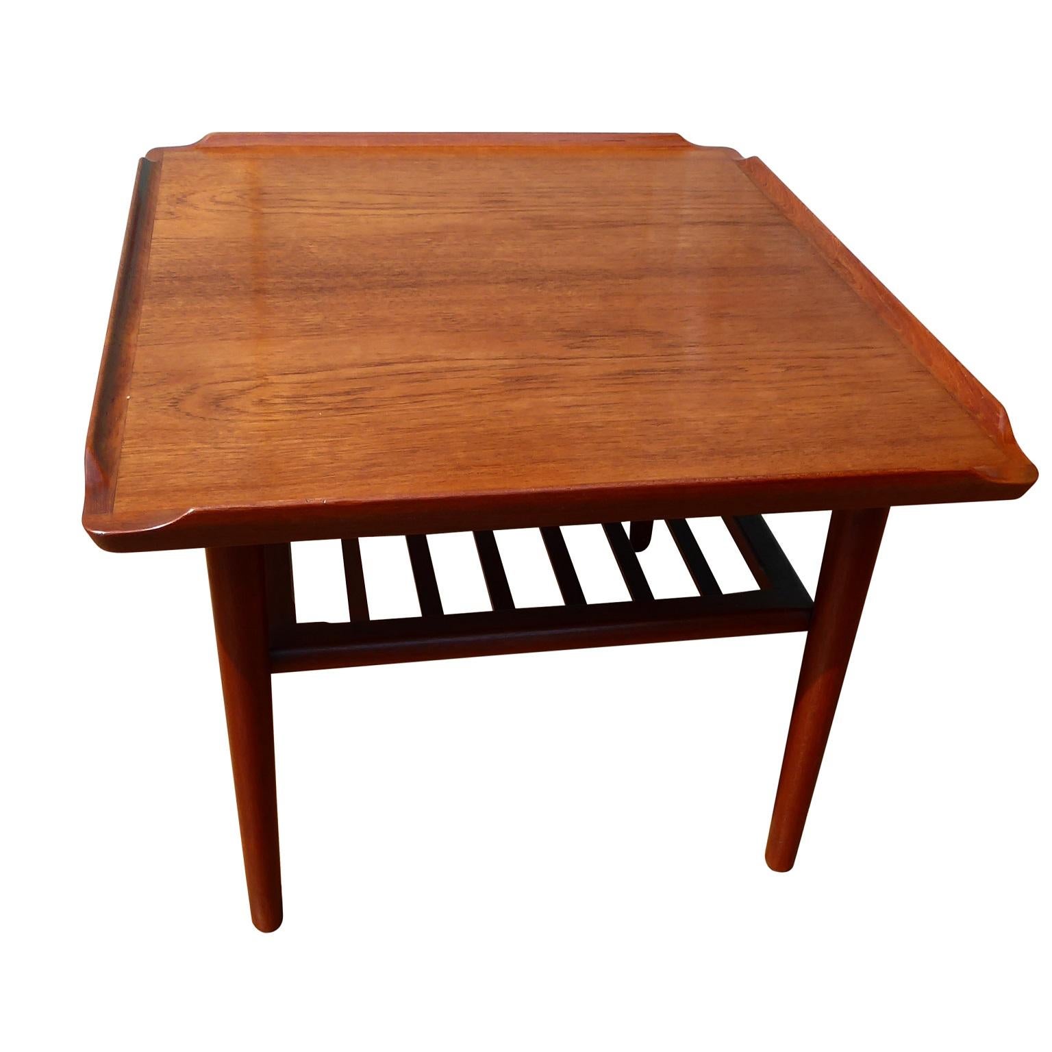 Danish teak coffee table by Holger Georg Jensen for Kubus, 1960s

Great size Danish teak coffee table designed by Holger Georg Jensen and manufactured by Kubus, circa 1960s. 
Square in shape, with a magazine shelf and 4 tapered legs. Makers label on