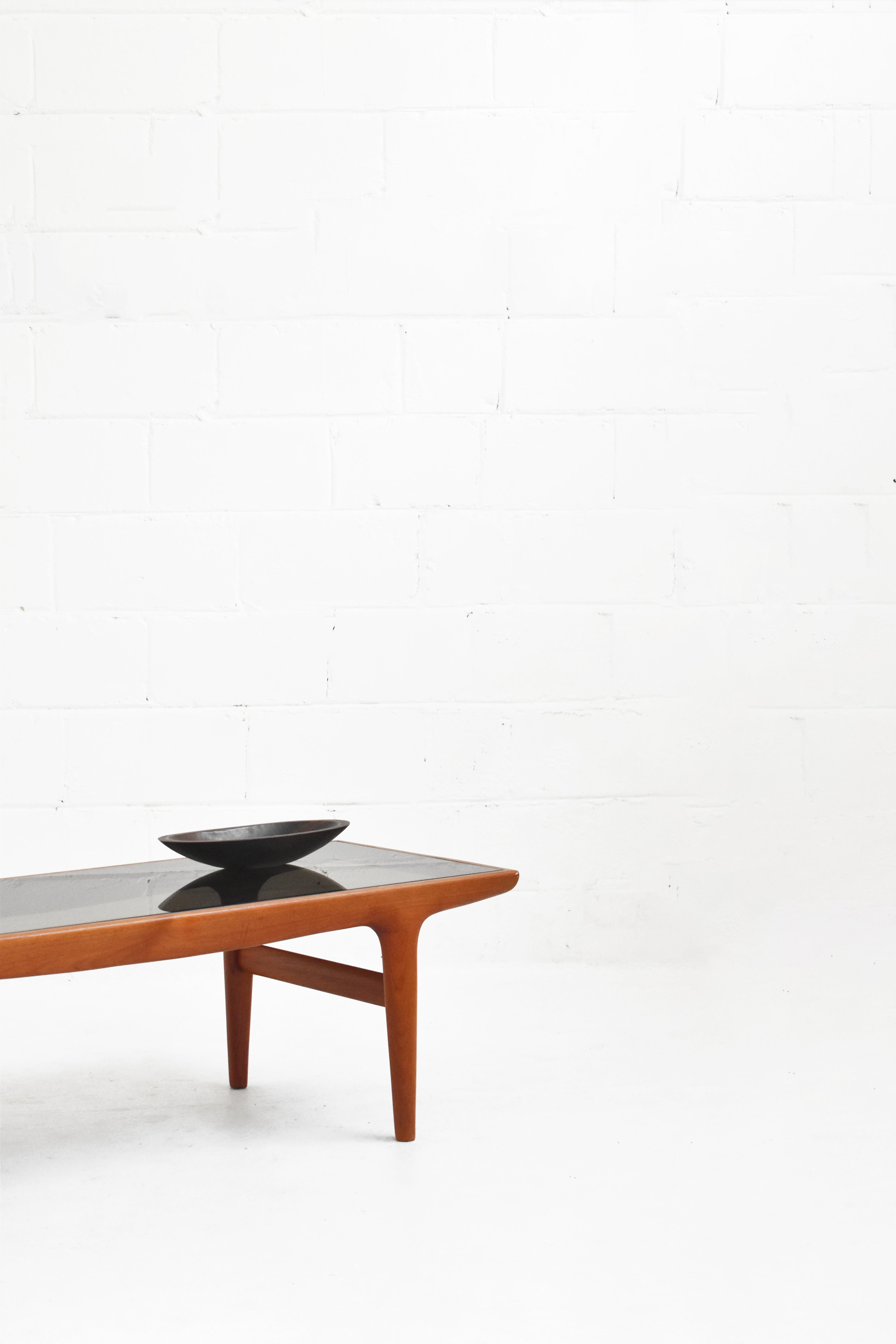 Stunning coffee table in teak and smoked glass. Faint scratching on glass top, but overall in great vintage condition. 

Measurements:
Rectangular: 61 1/2