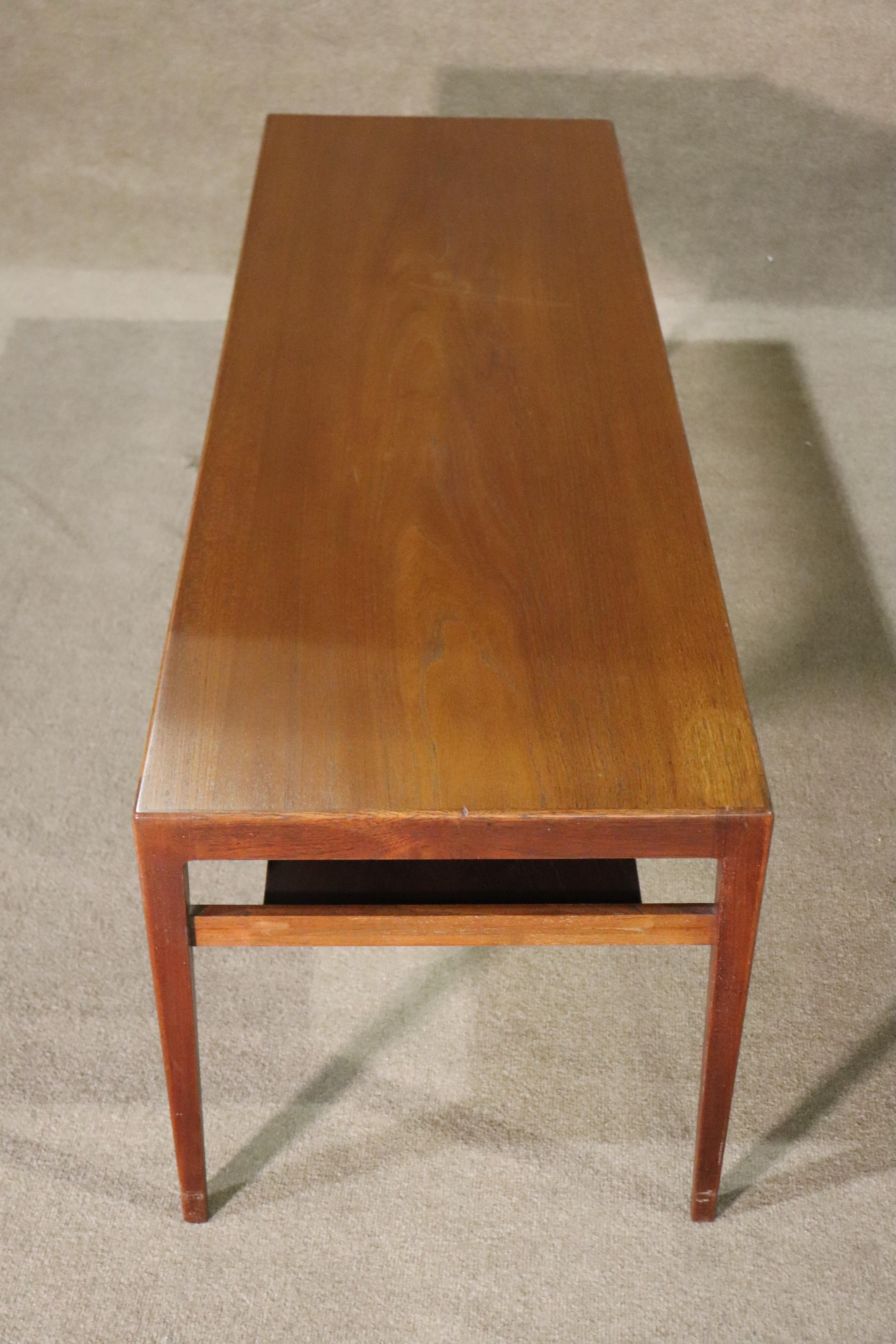 Mid-century modern Danish made coffee table. Teak grain, hidden shelf and tapered legs.
Please confirm location NY or NJ