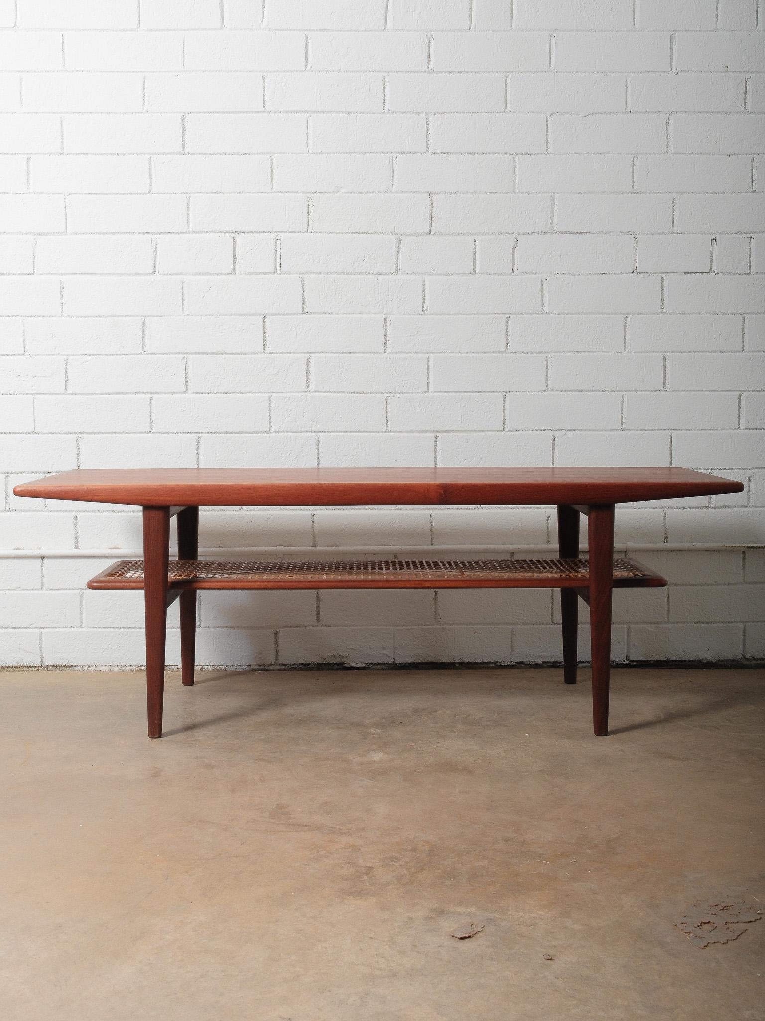 A beautifully crafted Danish modern teak coffee table designed by Niels Bach, dating to the 1960s. This elegant piece features a long, sculpted top with softly rounded edges and a warm teak grain that displays the rich coloration characteristic of
