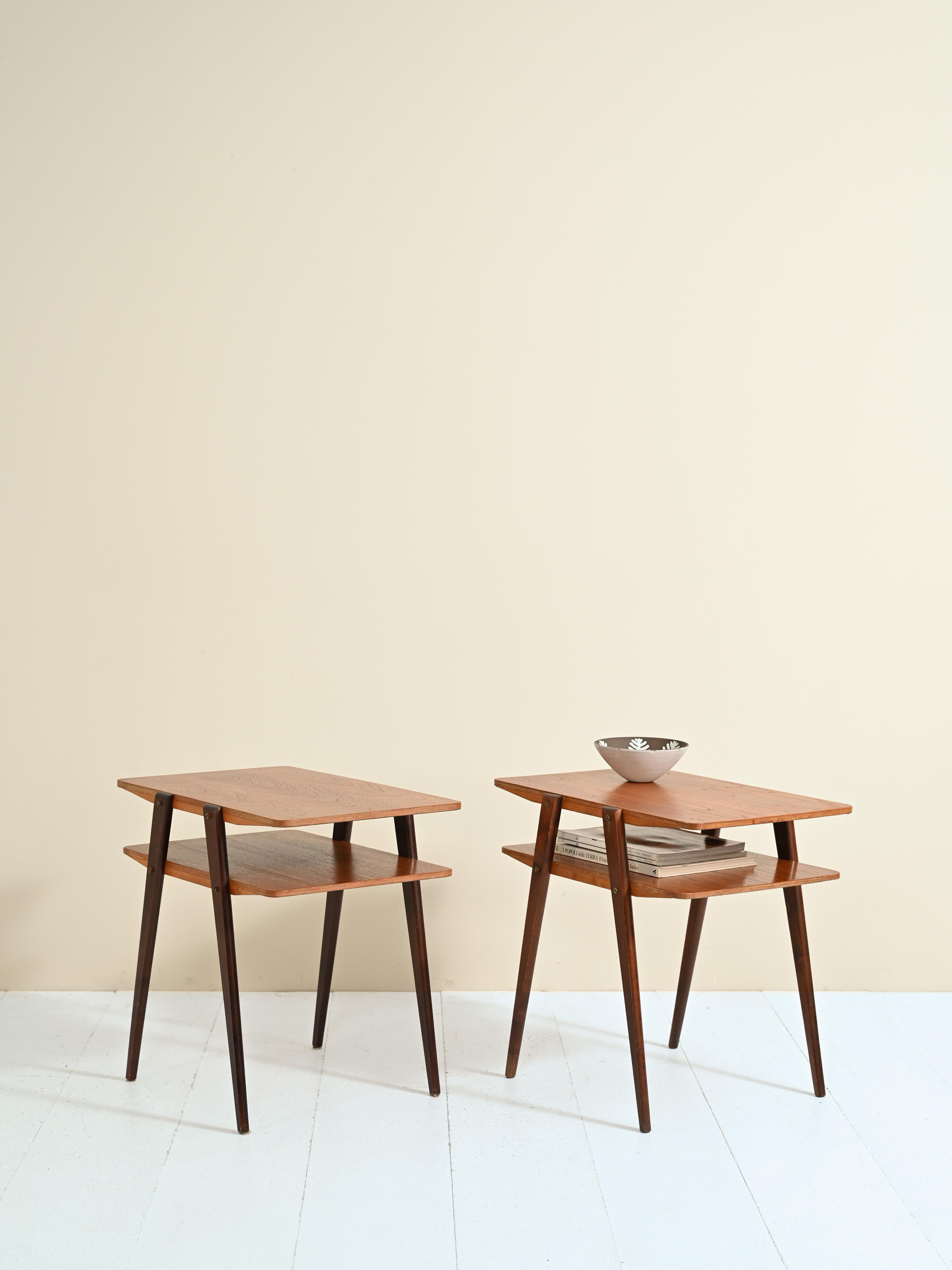 Pair of Scandinavian nightstands/coffee tables in teak wood.
 
The clean, modern lines of these tables only to be found in the best tradition of Scandinavian design.

The frame features a double shelf, ideal as a second table top. The tapered legs