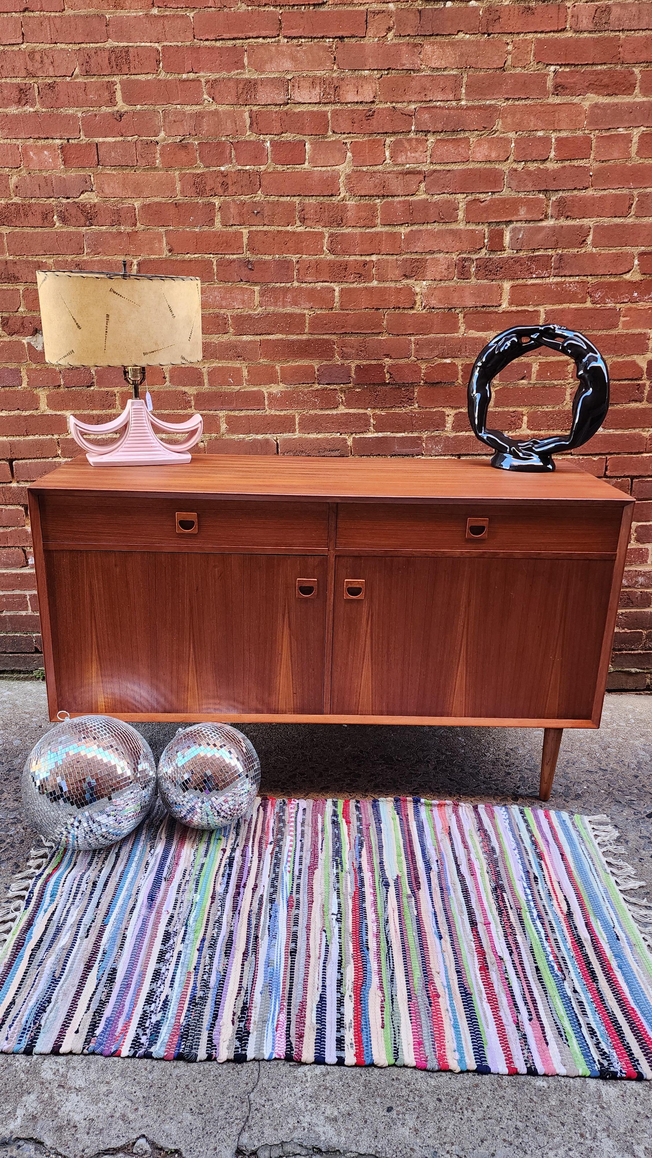 This lovely Danish teak credenza was designed by E. Brouer. The perfect size for under the television or a a dining server, the piece has cabinet doors and drawers for plenty of storage.