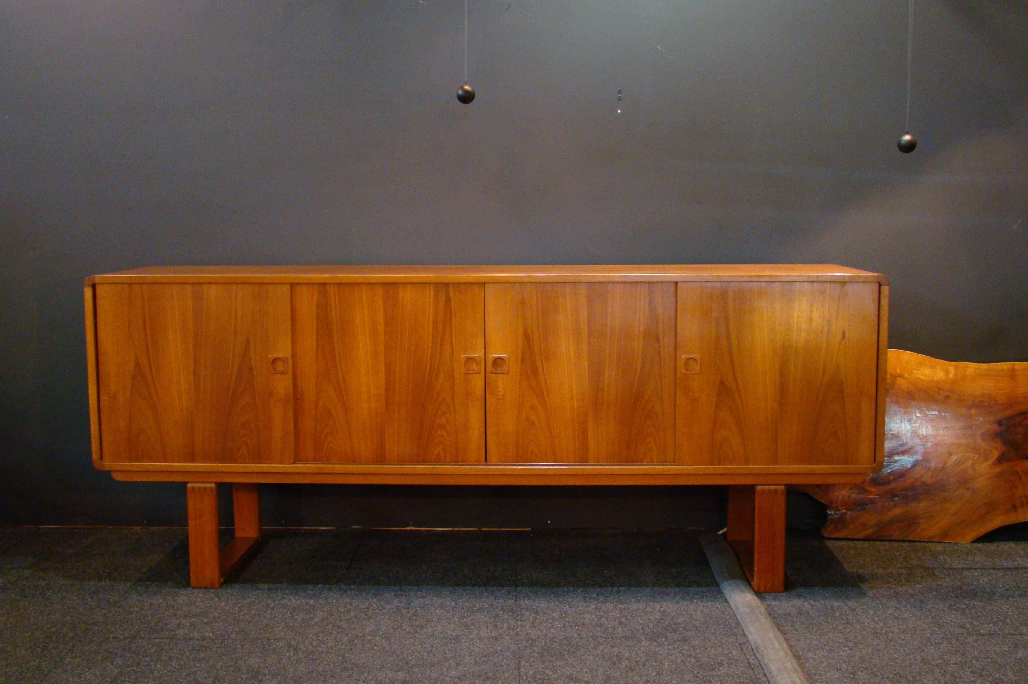 Vintage teak sideboard circa 1969 credited to Klausen and Son, Silkeborg, Denmark. The cabinet has four pass-by doors concealing four felt lined flatware drawers left, a large 39