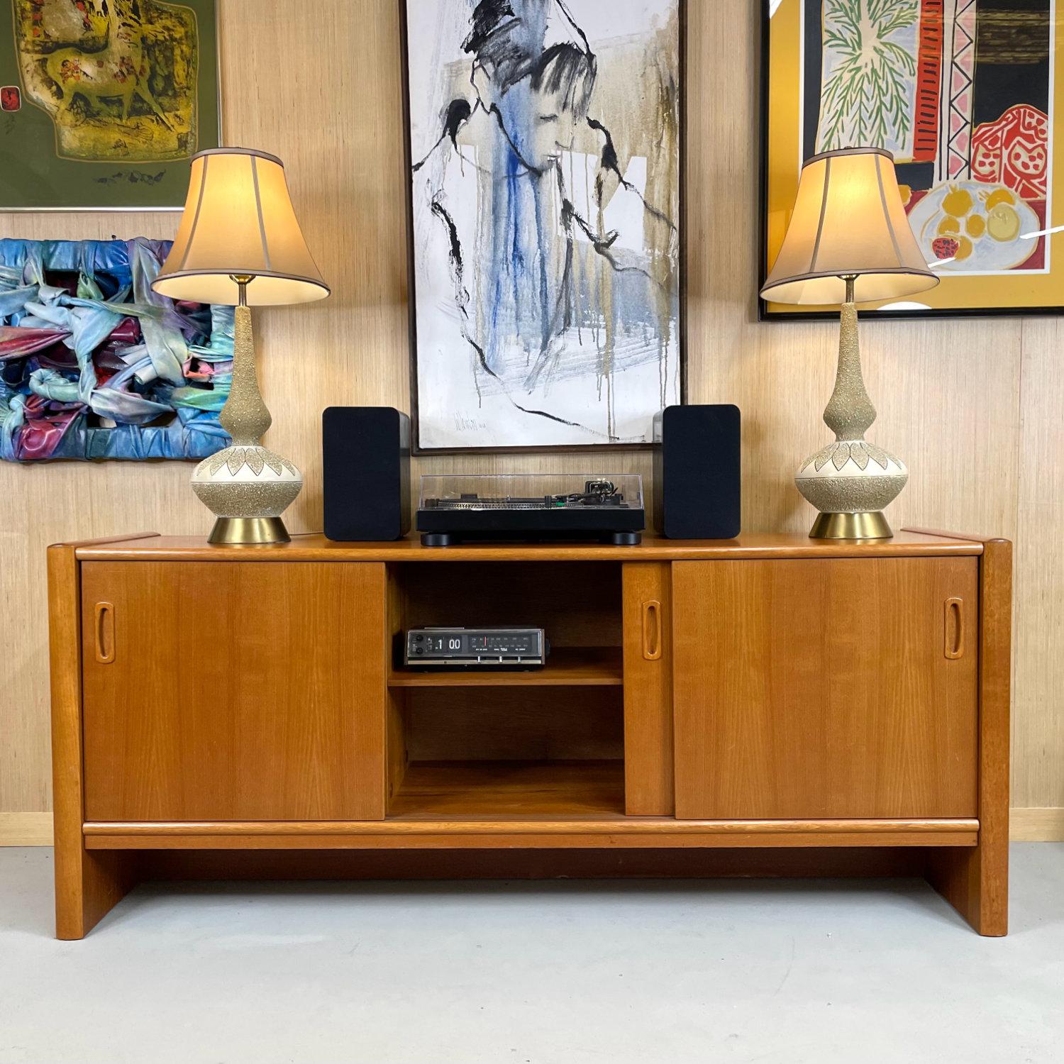 Danish teak credenza with sliding doors. Use this high-capacity storage solution as a TV Stand / media center or office credenza. The sliding doors allow easy access to the ample cabinet space inside. A single felt-lined drawer resides in the upper