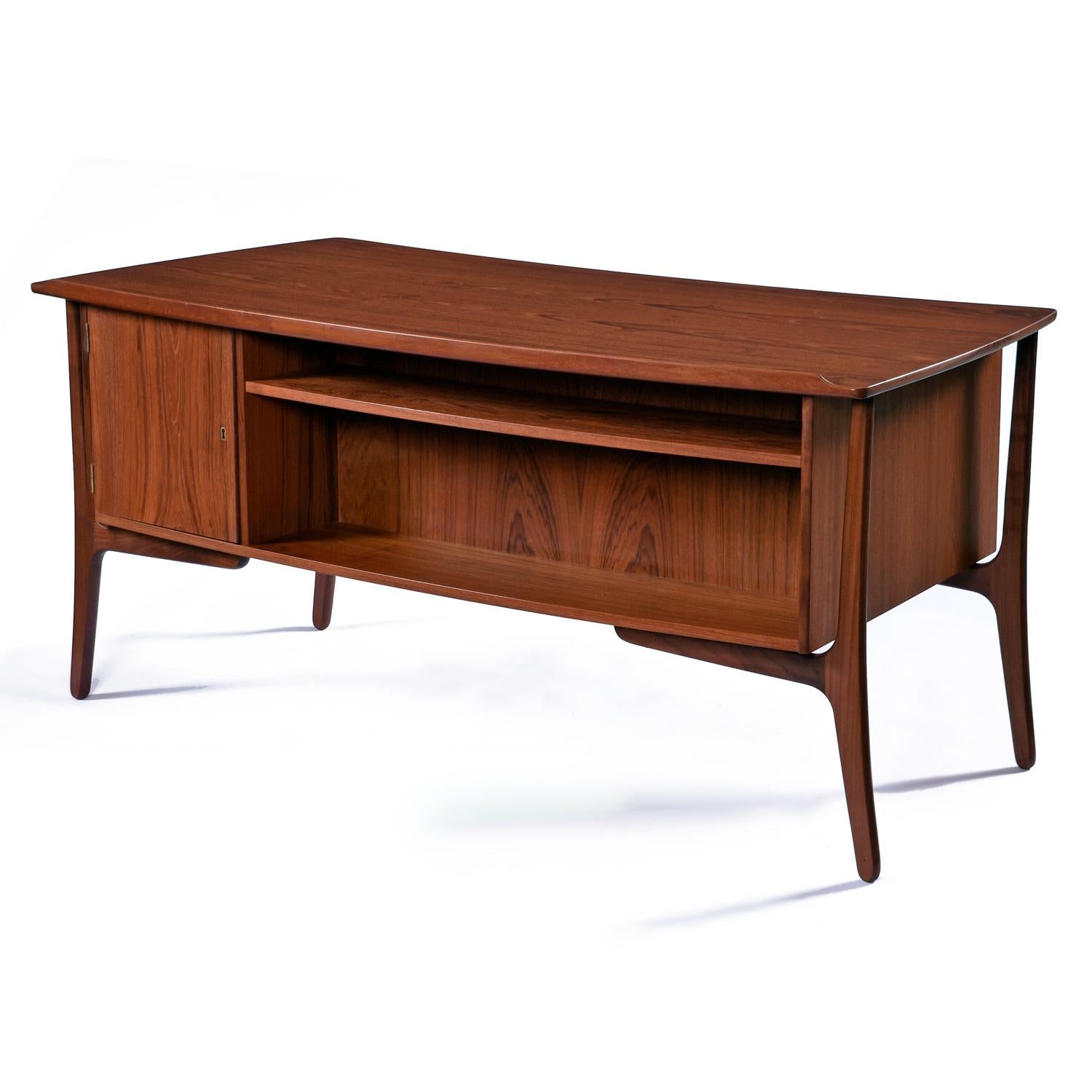This dazzling desk appears to float in mid-air.  Dark, tawny, solid teak legs suspend the cabinet with architectural precision.  When combined with the curved, 