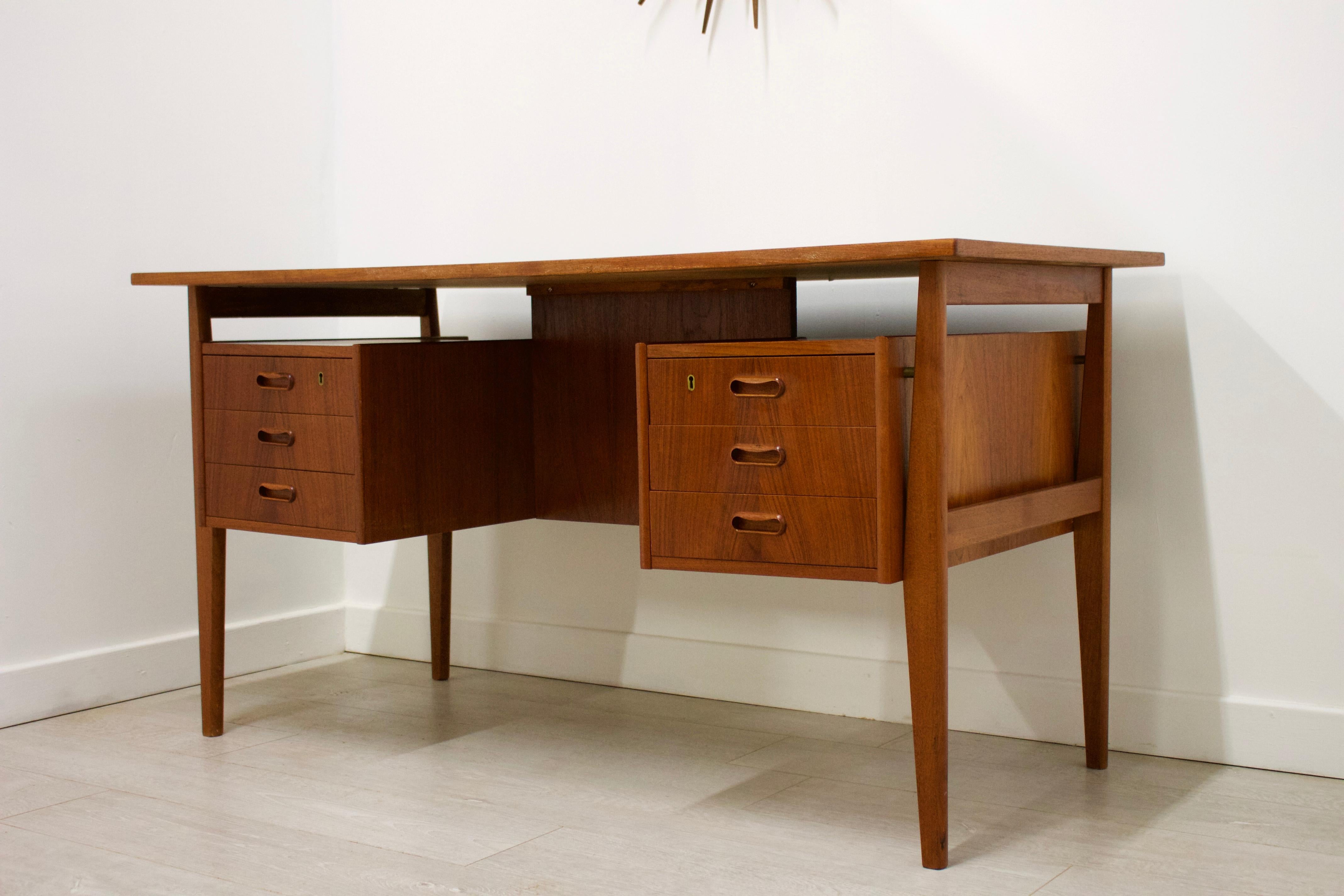 - This is a very stylish Danish teak desk in the manner of Kai Kristiansen.
- Features a floating top, 6 drawers (3 either side) and a bookshelf at the back.