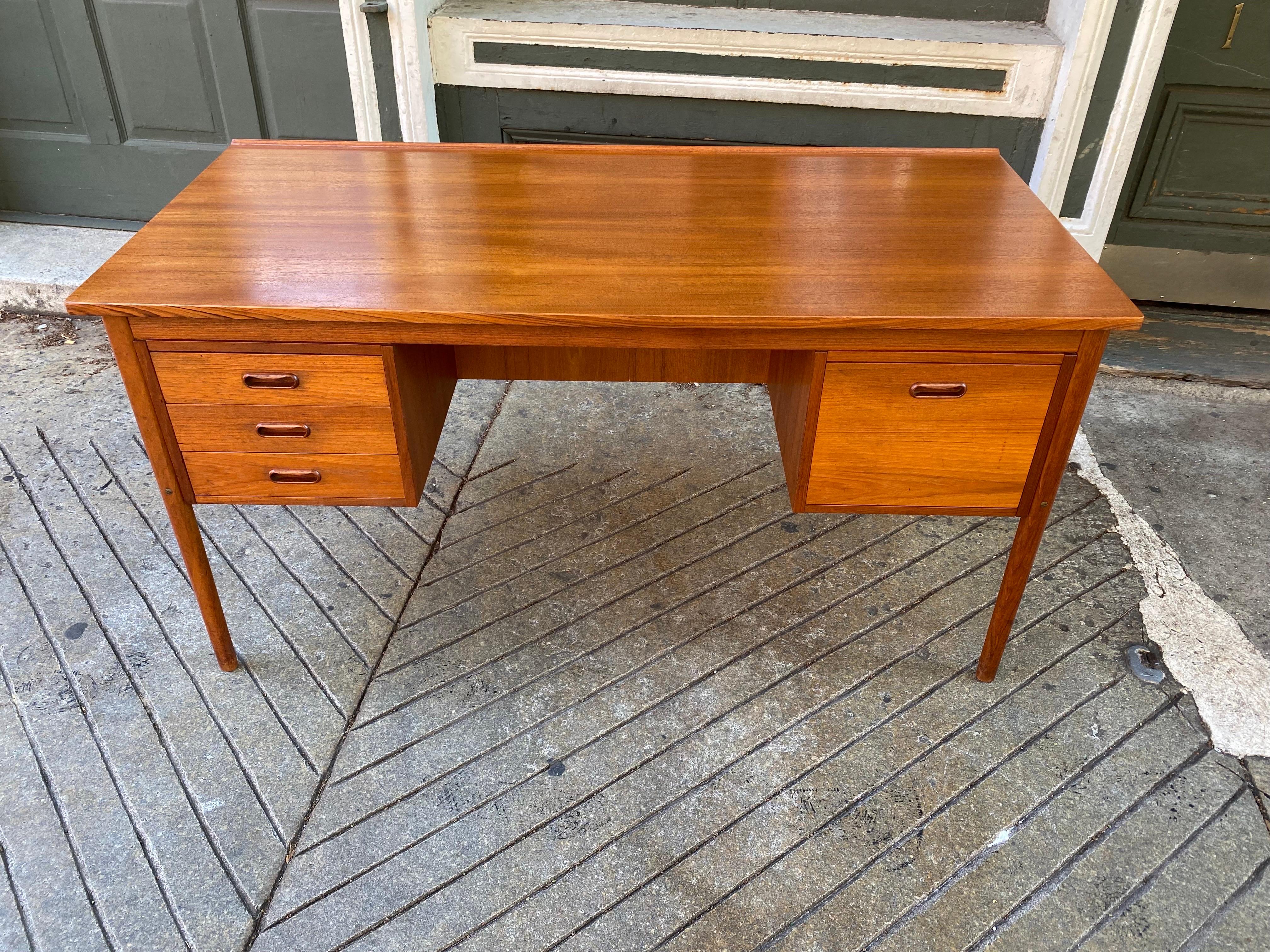 Danish Teak Desk with a Front Bookcase. Top refinished and overall very clean condition! Nice design with bookcase in front makes this a perfect desk for the center of the room! 3 smaller drawers on left and one deep drawer on right. Space between