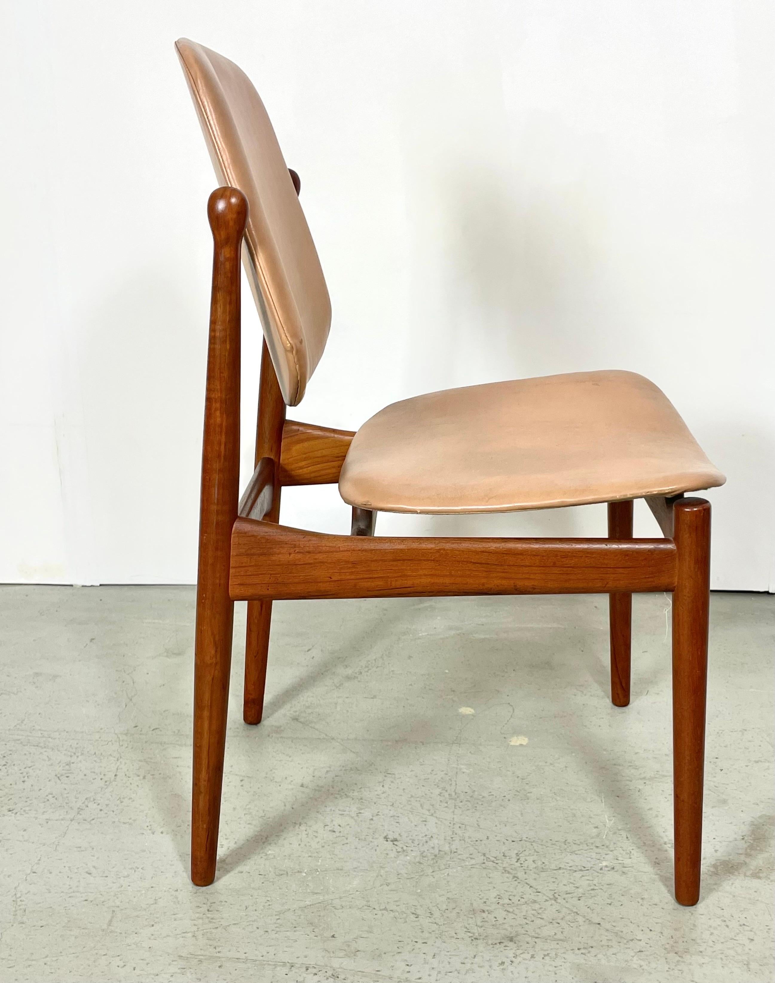 A rare set of four dining chairs model 203 designed by Arne Vodder. Produced by France & Daverkosen in Denmark, during the 1950s. They feature a solid teak wooden frame with the original upholstery in faux leather in a cogniac color. This minimalist