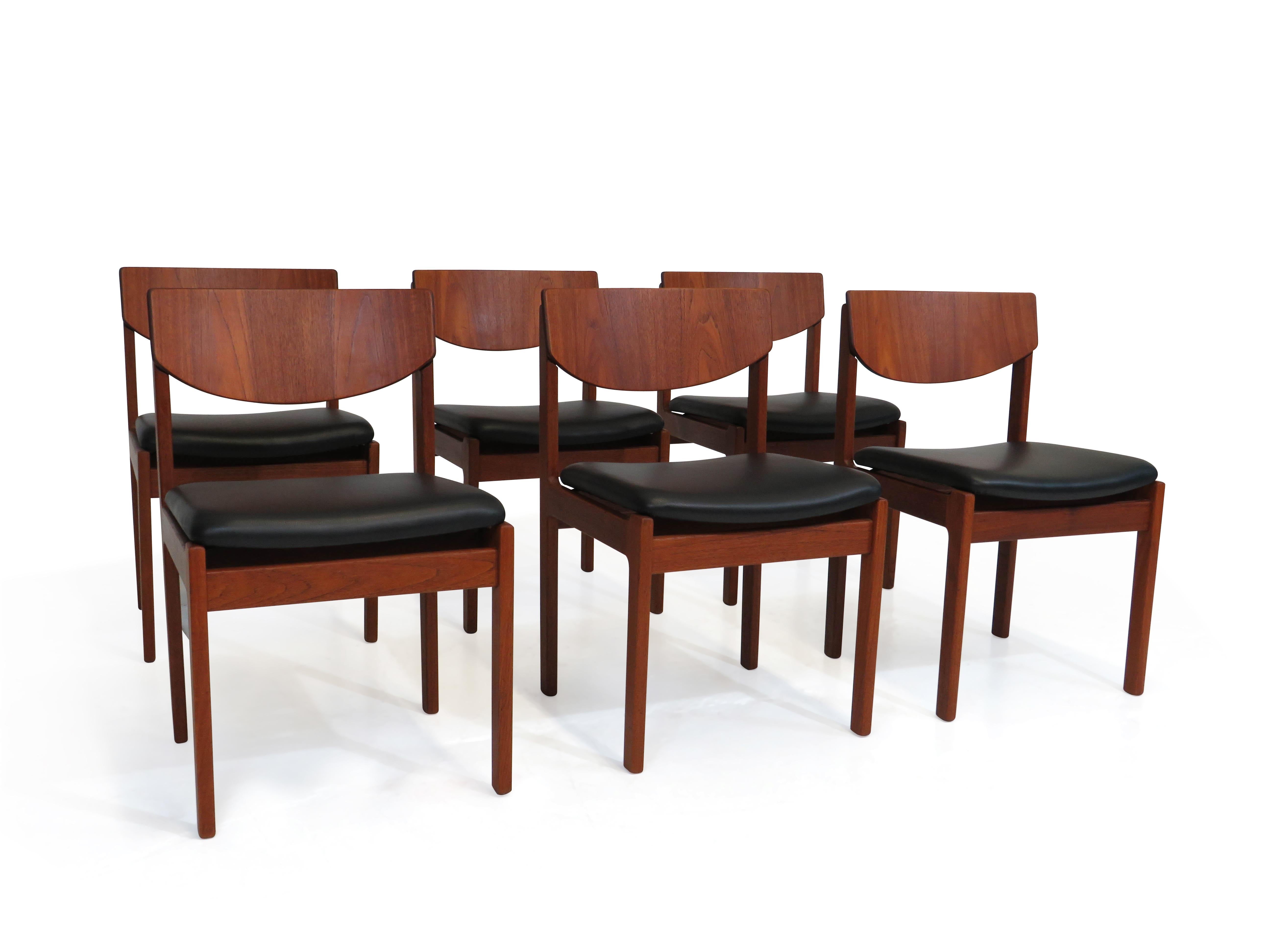 Six mid-century dining crafted of solid old-growth teak, with sturdy joinery, comfortable curved backrest and newly upholstered seats in black leather. Manufactured in Denmark during the early 1960s. The wood has been professionally restored in a