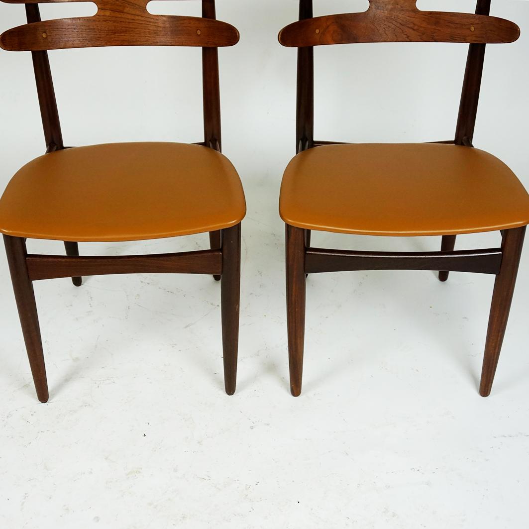 This rare set of organic shaped Scandinavian Modern teak dining chairs is designed by Johannes Andersen in the 1960s and produced by Bramin Mobler, mod. no 178. They feature solid teak wood frames and moulded teak veneer backrests with brass