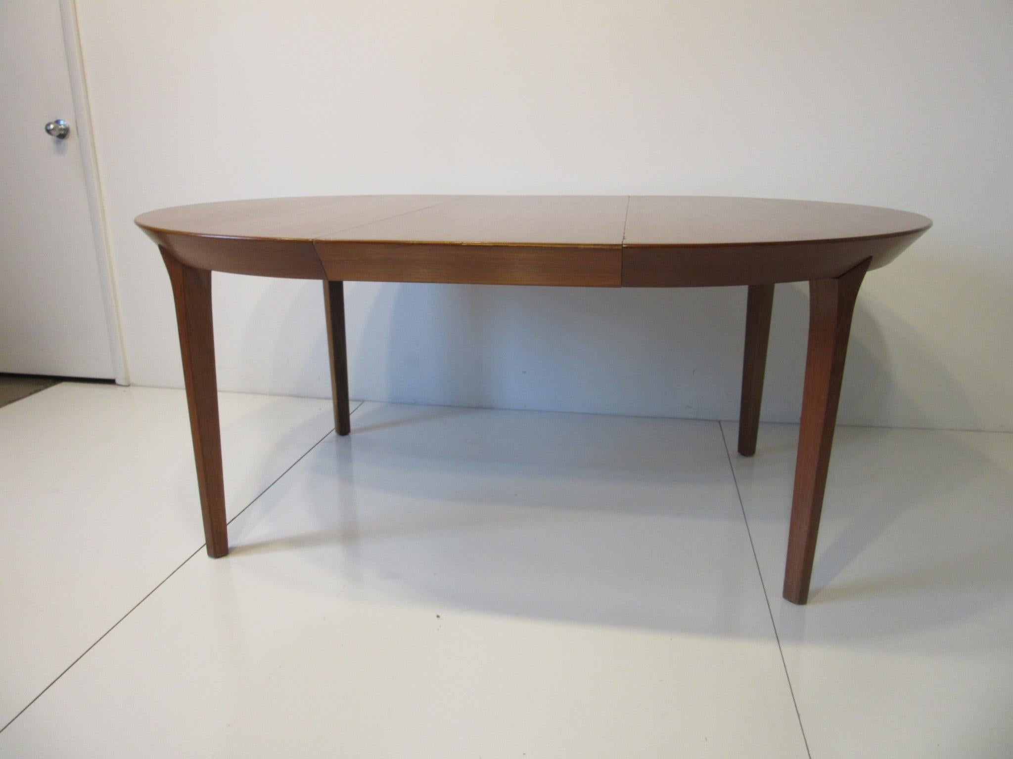 A well constructed teak dining table with 2 large 19