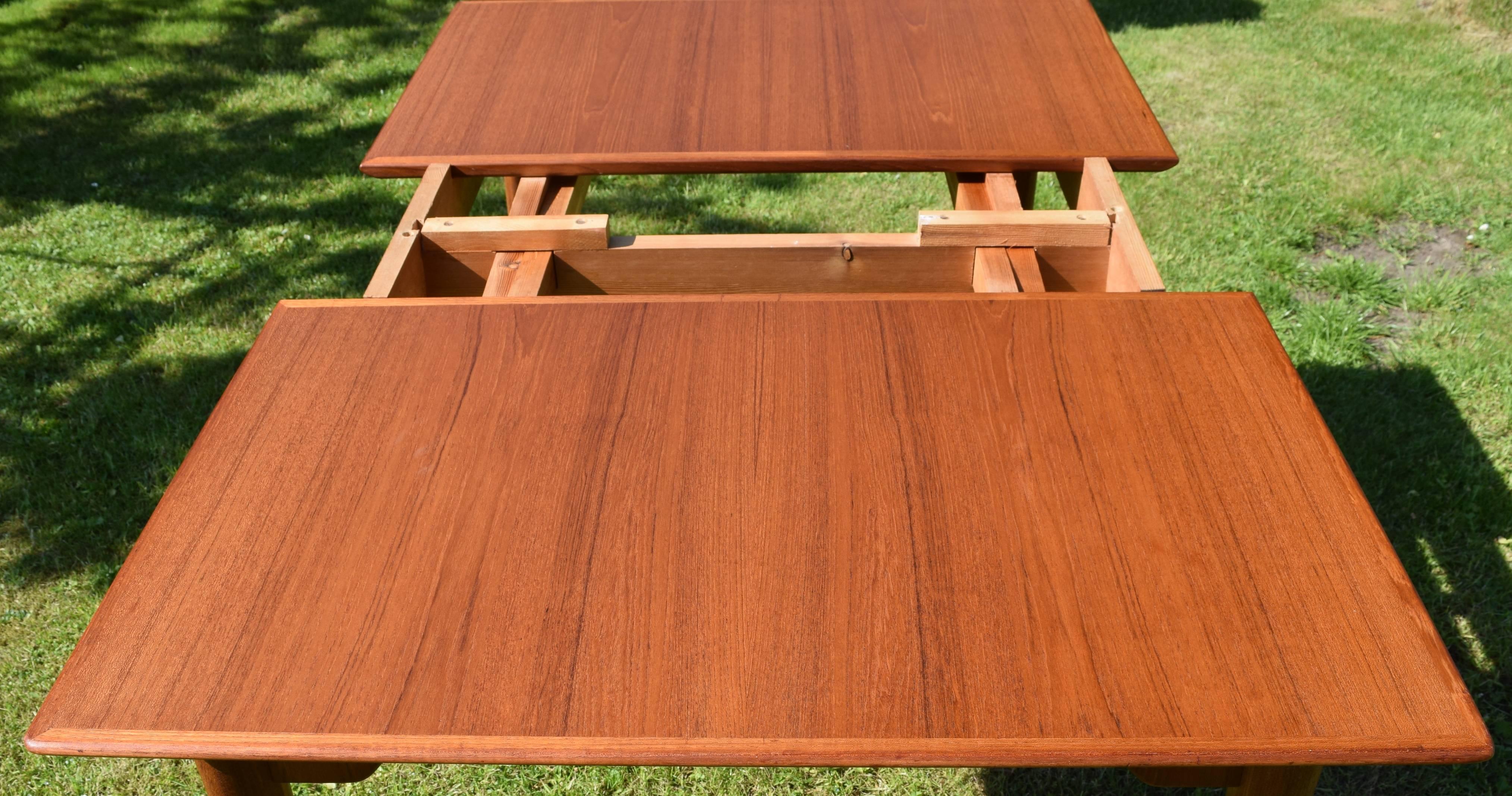 Teak dining table with extension plates manufactured in Denmark in the 1960s. The table features elegant turned and tapered legs. The splayed legs give the table a form reminiscent of designs by Poul Volther from the same period. There are very few