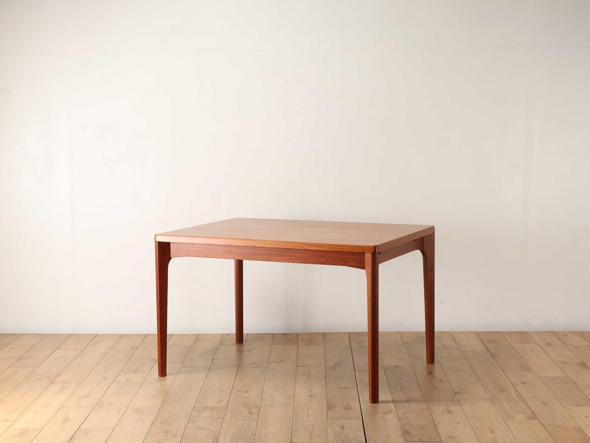Draw-leaf table in teak, estimated 1960s, designed by Henning Kjaernulf, Denmark. It is not a normal sliding extension table, but has an unusual specification with the left and right blades built into the inside of the body. Made from high-quality