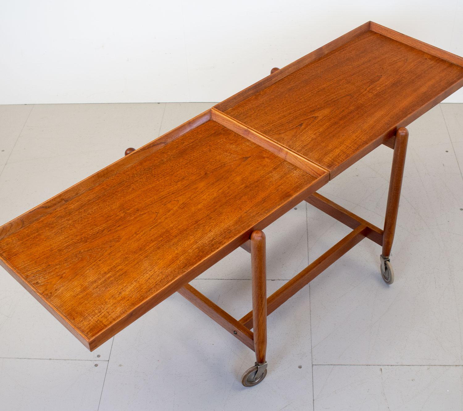 Stylish and practical 1960s Danish teak drinks trolley by Poul Hundevad for Hundevad Møbelfabrik. It doubles as a serving trolley by removing the bottom shelf and sliding it next to the top shelf. The bottom shelf can also be used as tray. This item