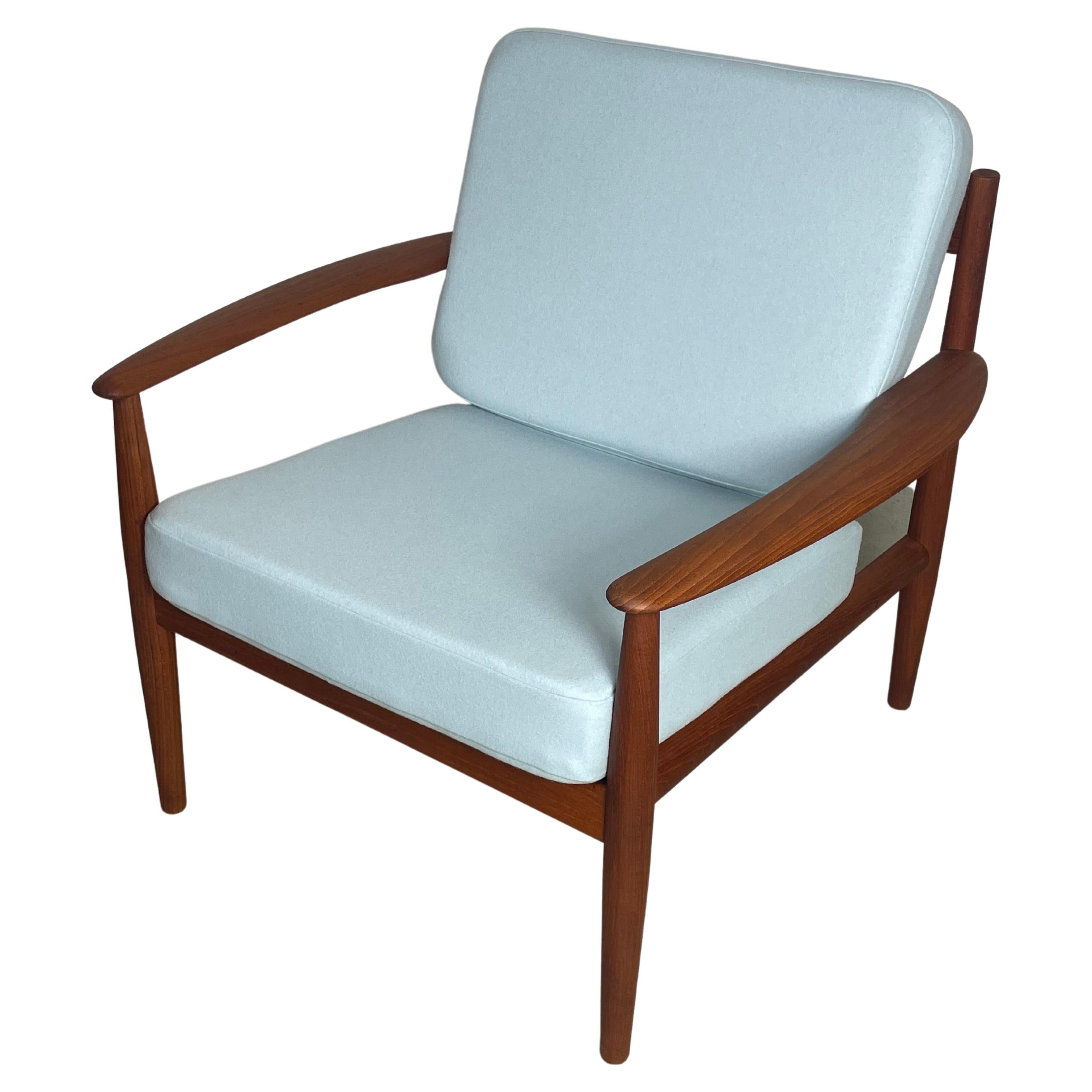 Classic easy chair by Grete Jalk for France & Son. Made in Denamark during the 1950s. Produced by France & Son. Features a high-quality solid wooden frame made of teak with new upholstery and removable cover in a high-quality woolen fabric.