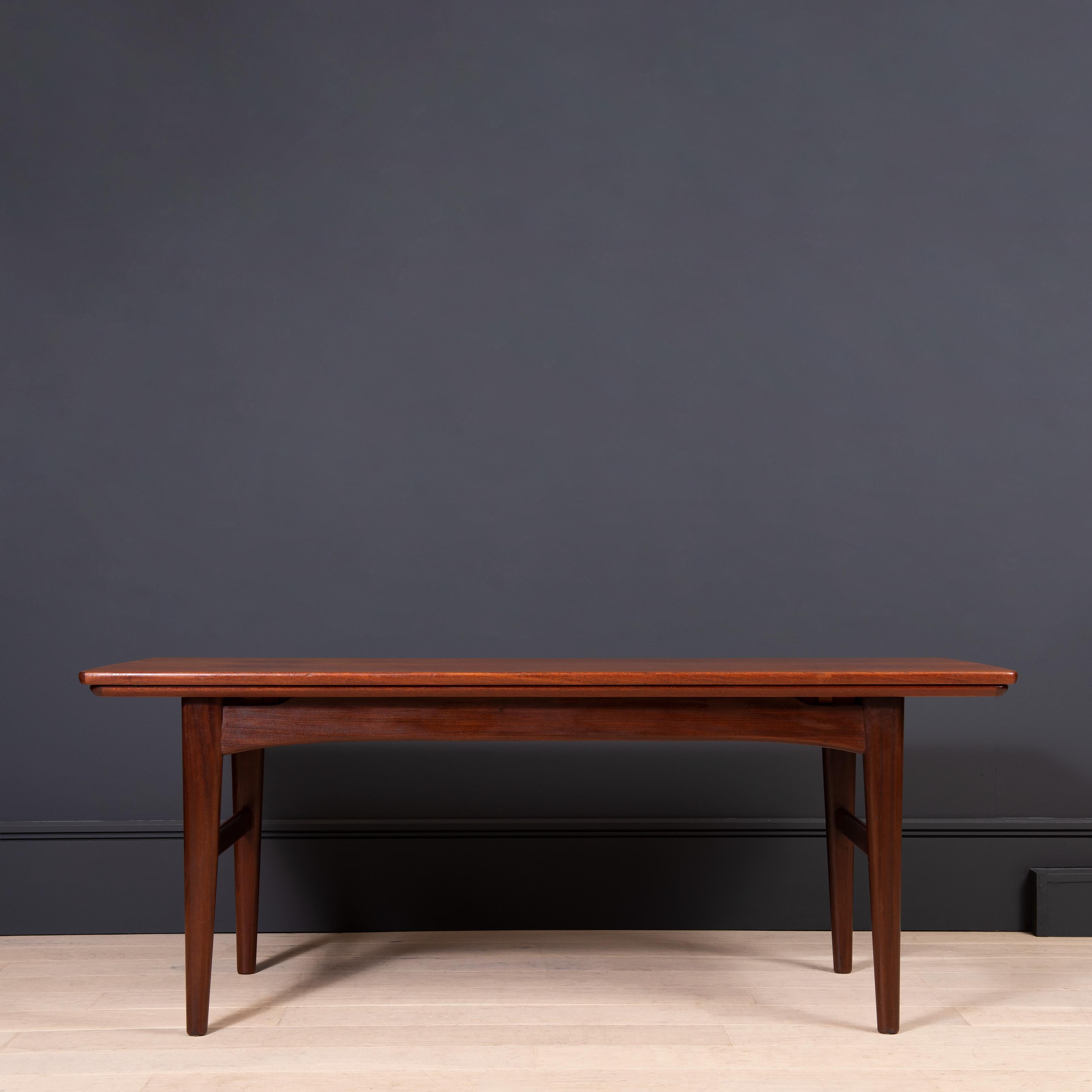 Innovative metamorphic table design from circa 1960. Wonderful coloured Teak. 
This clever design coverts from coffee/sofa table to a very practical dining table in a few simple moves. The table top has its extensions along the length rather than